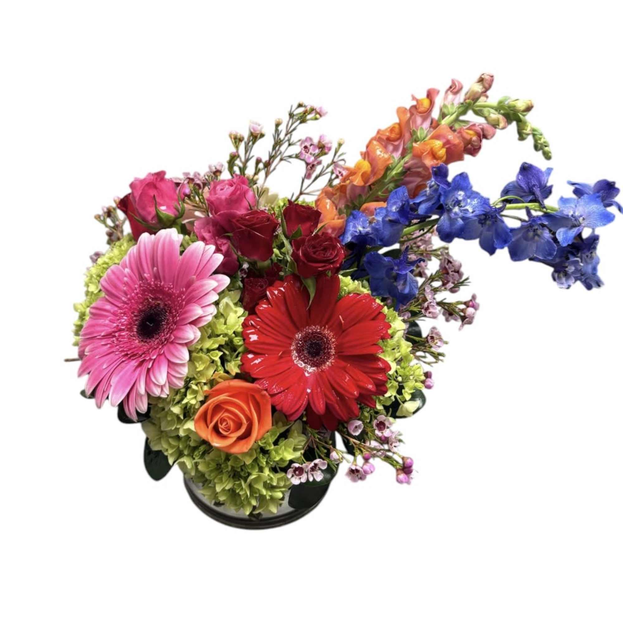 Colorful mixed bouquet with gerbera daisies, roses, and blue flowers in a low vase