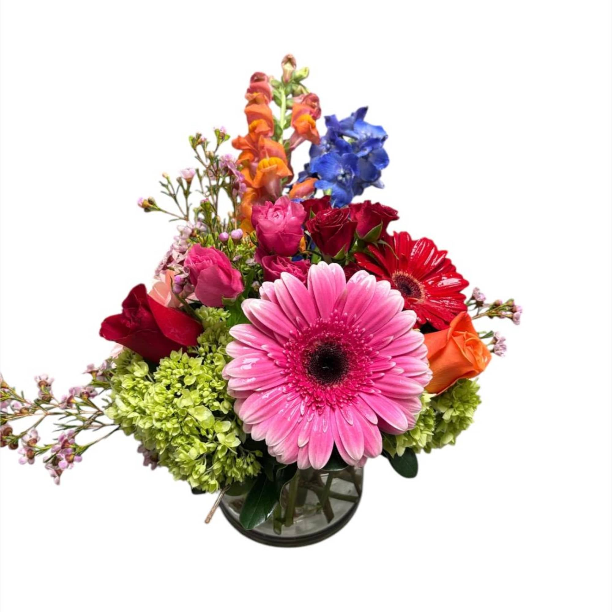 Mixed bouquet with pink gerbera, roses, and blue flowers in a glass vase
