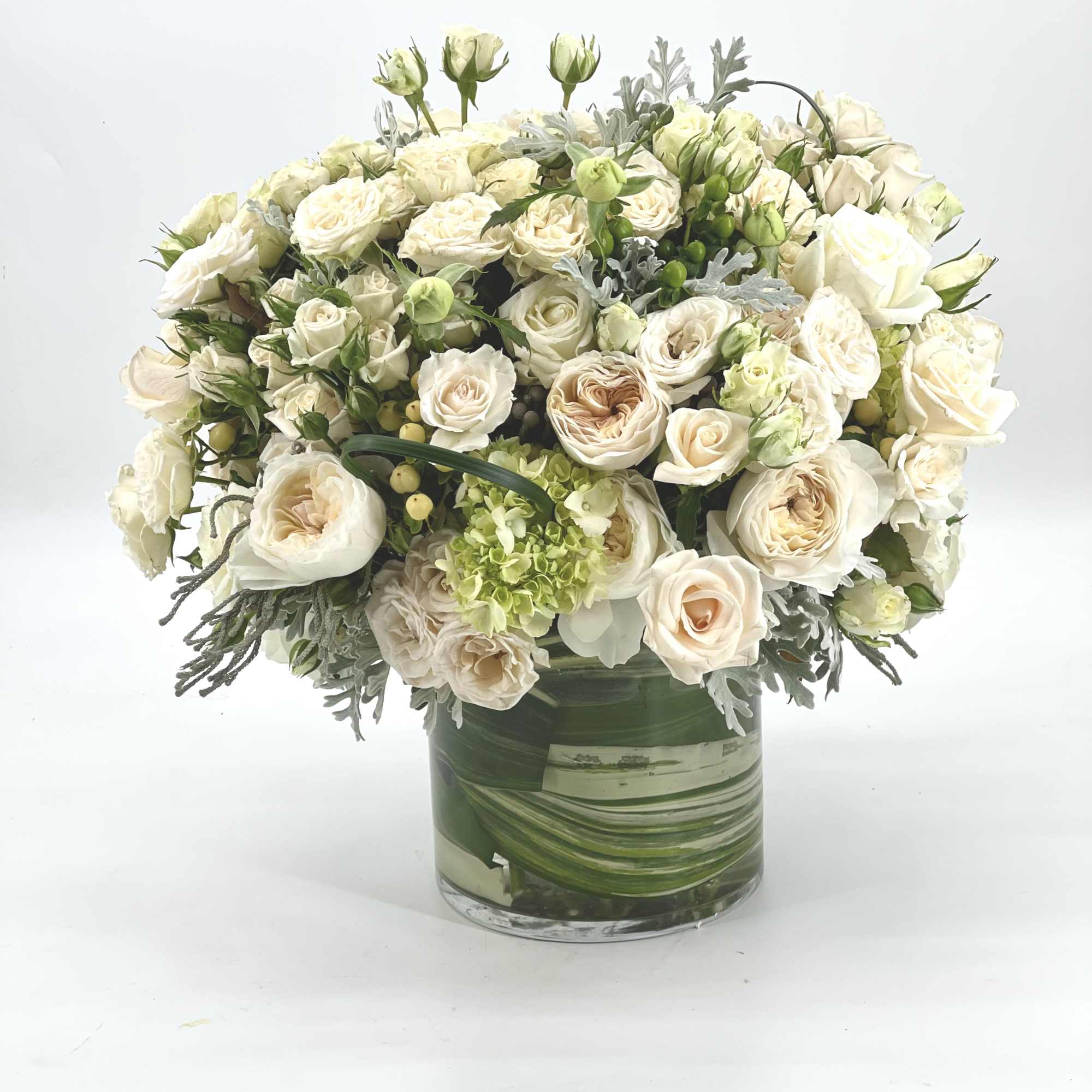 Cream rose bouquet in a clear glass vase