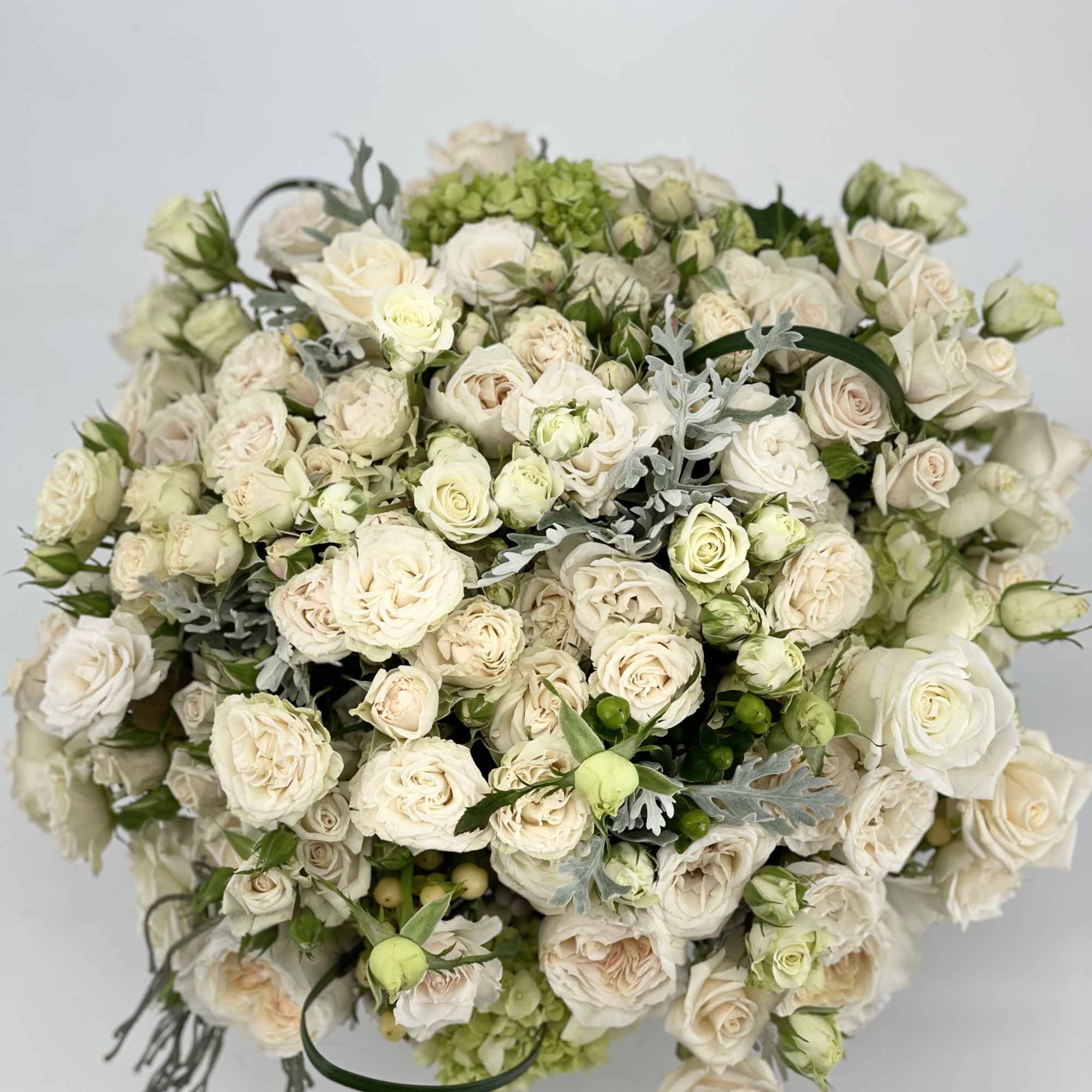 Large bouquet of cream roses and pale green blooms