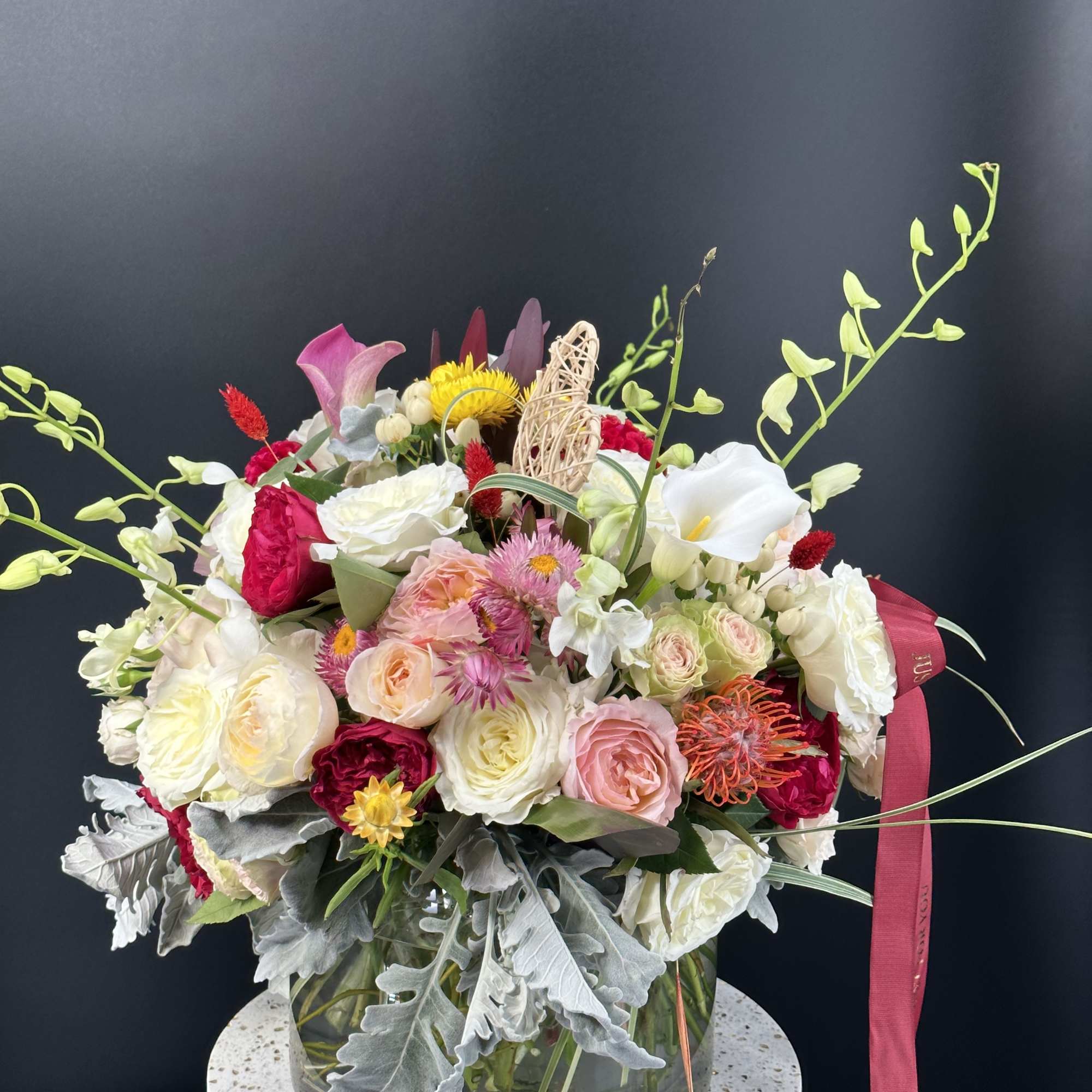 Mixed bouquet in a glass vase with pink, white, and yellow blooms