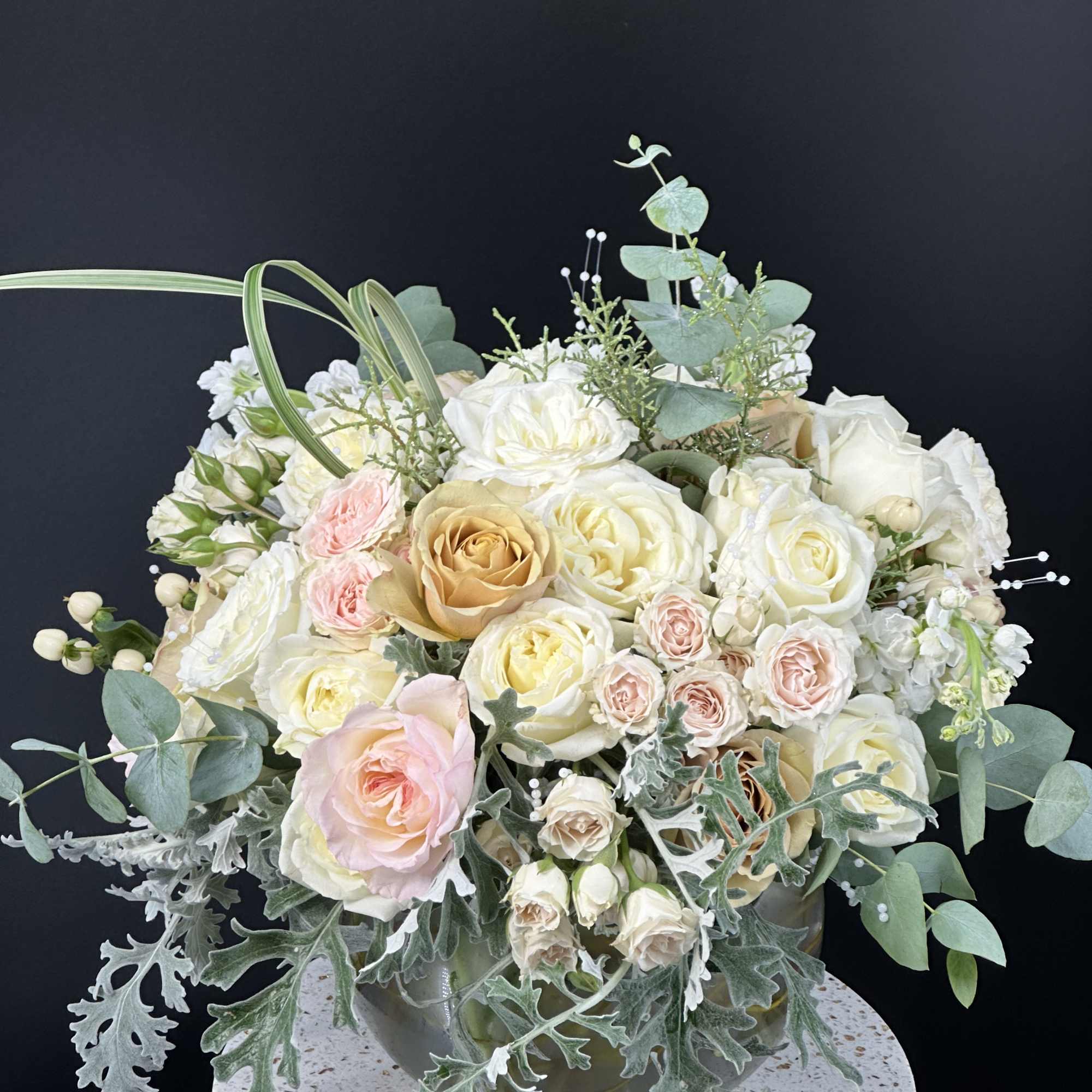 Cream and blush rose arrangement in a glass vase
