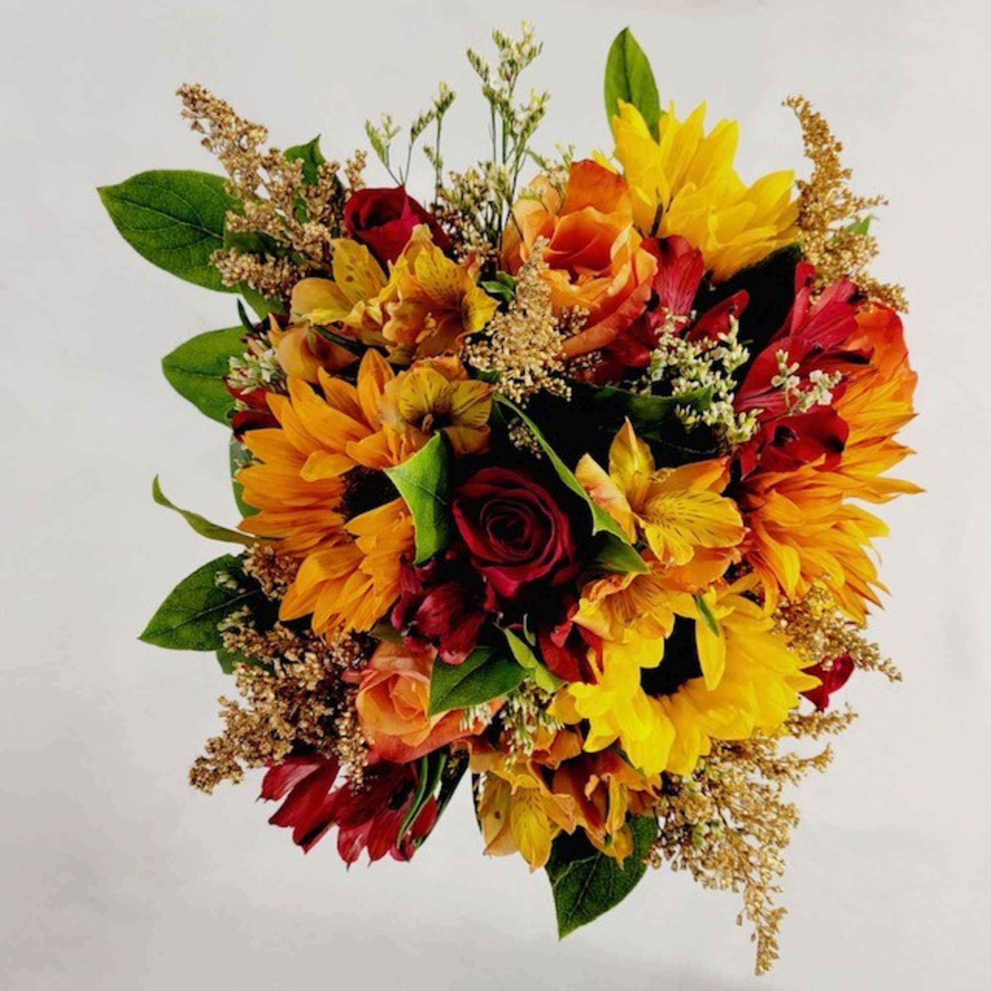 Bouquet of yellow, orange, and red flowers with green leaves