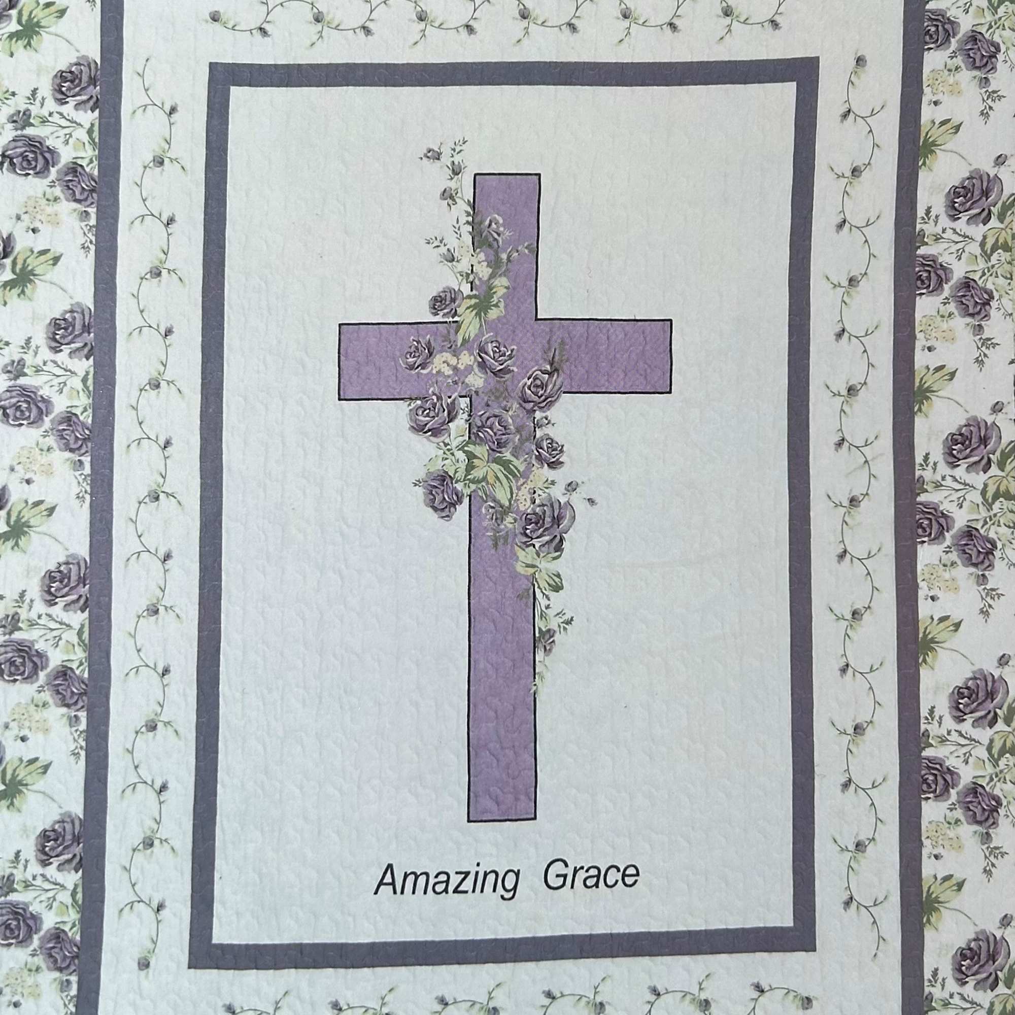 Quilt with a purple cross and floral border, labeled "Amazing Grace"