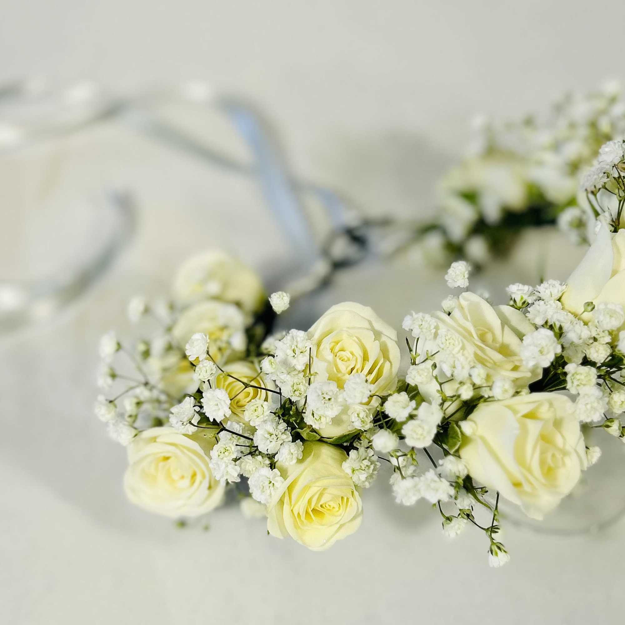 White rose floral crown with baby's breath on a clear band