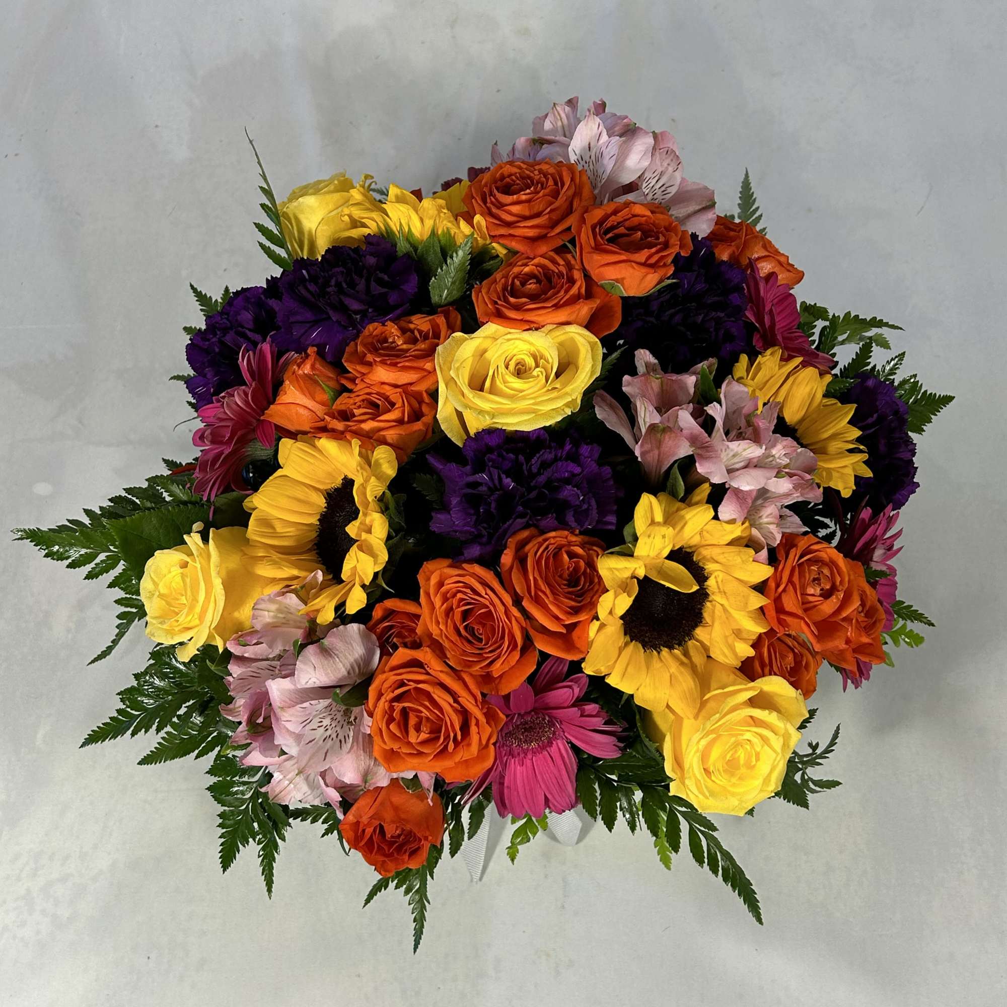 Bright, cheerful blooms spill from a round white hat box tied with, photo 2 of 2