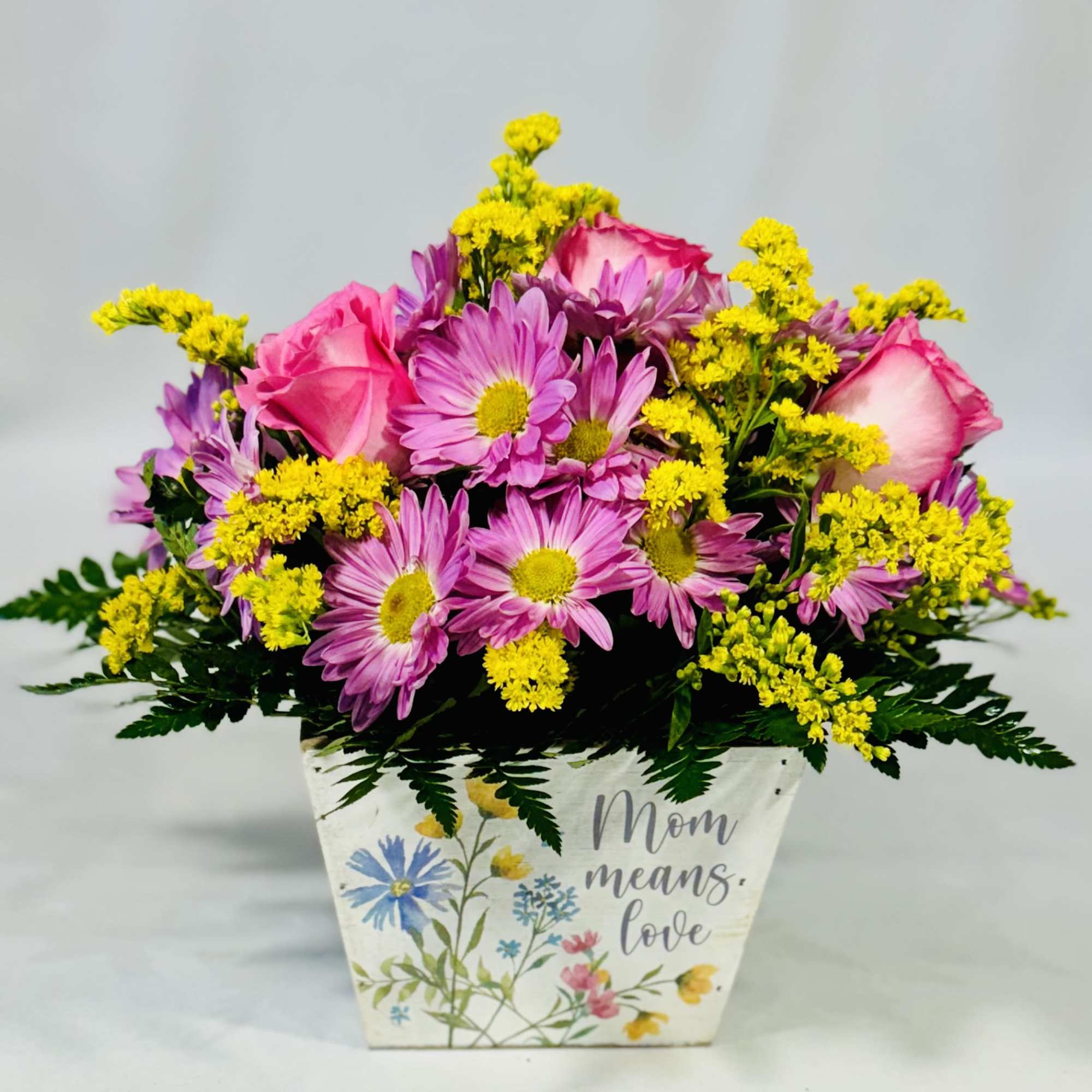 Pink roses and purple daisies in a decorative Mom planter