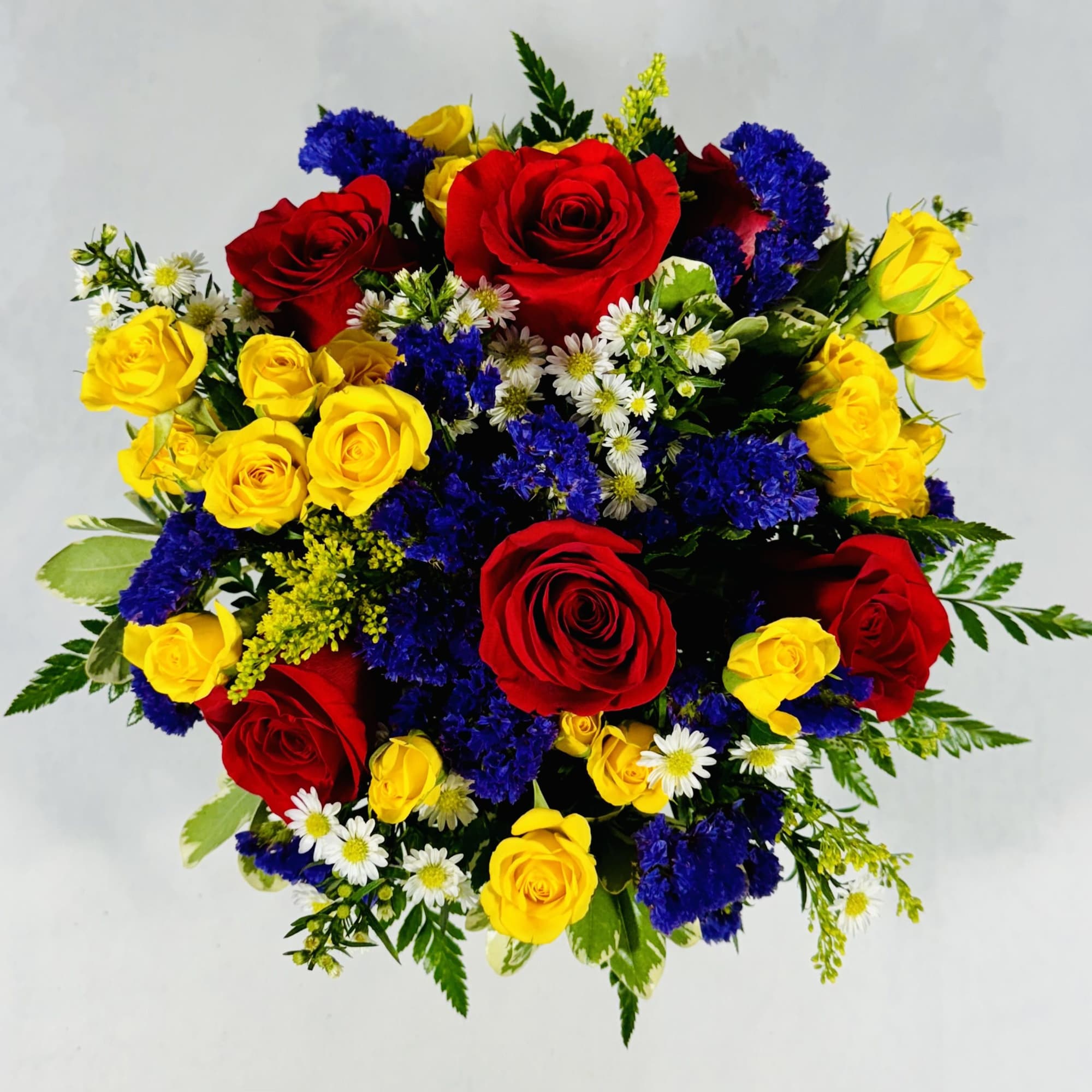 Bouquet of red and yellow roses with blue and white filler flowers