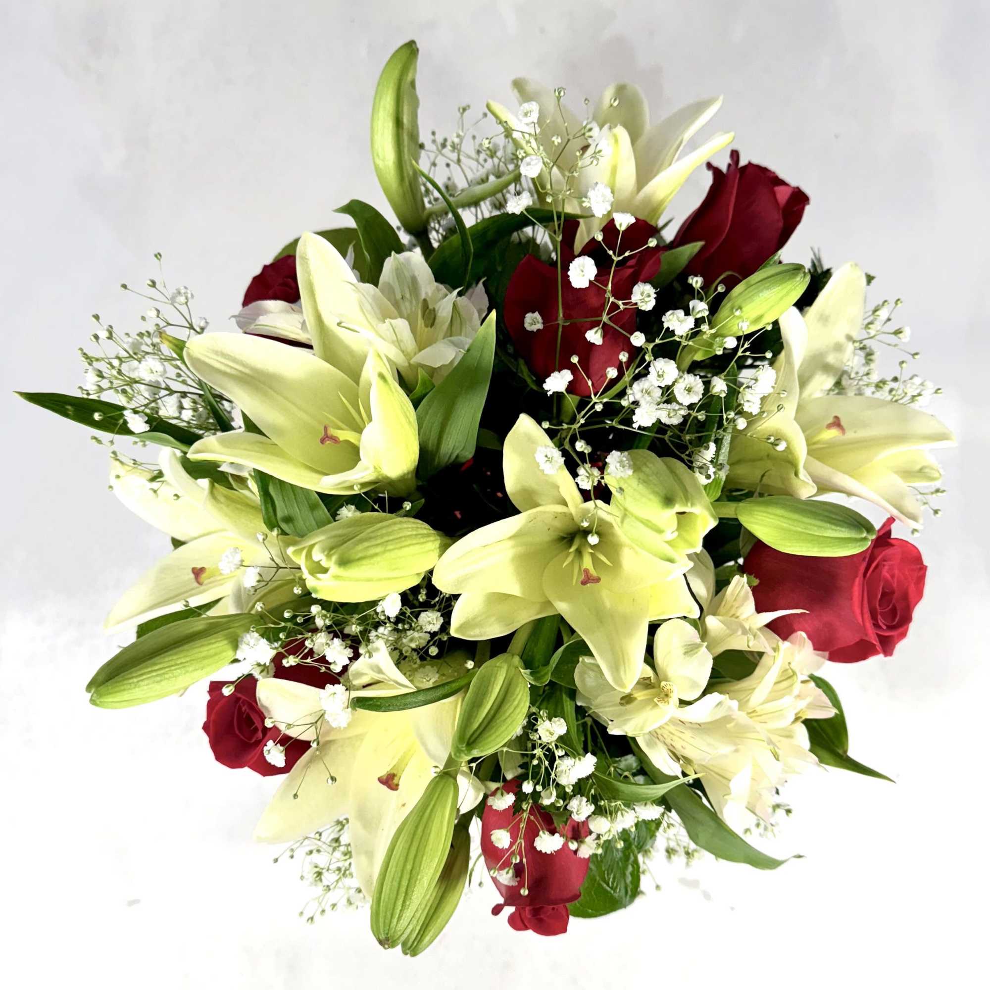 Large white lilies paired with deep red roses create a classic romantic