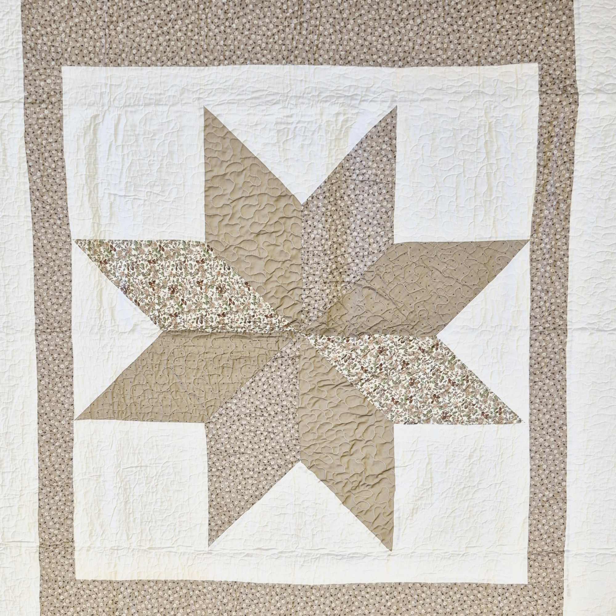 A handcrafted khaki star quilt brings quiet comfort and timeless style to