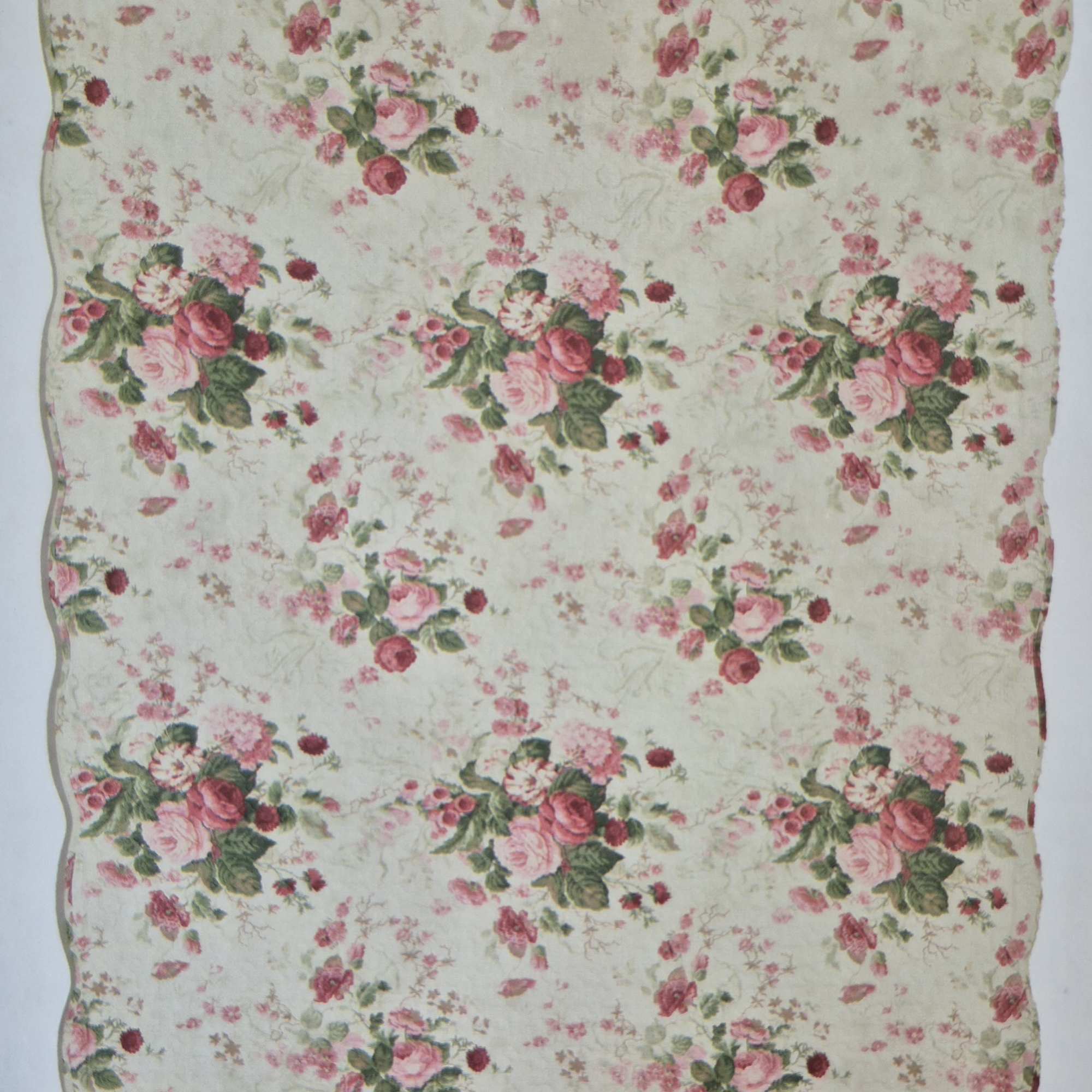 Floral-patterned quilt or fabric with pink rose bouquets on a cream background
