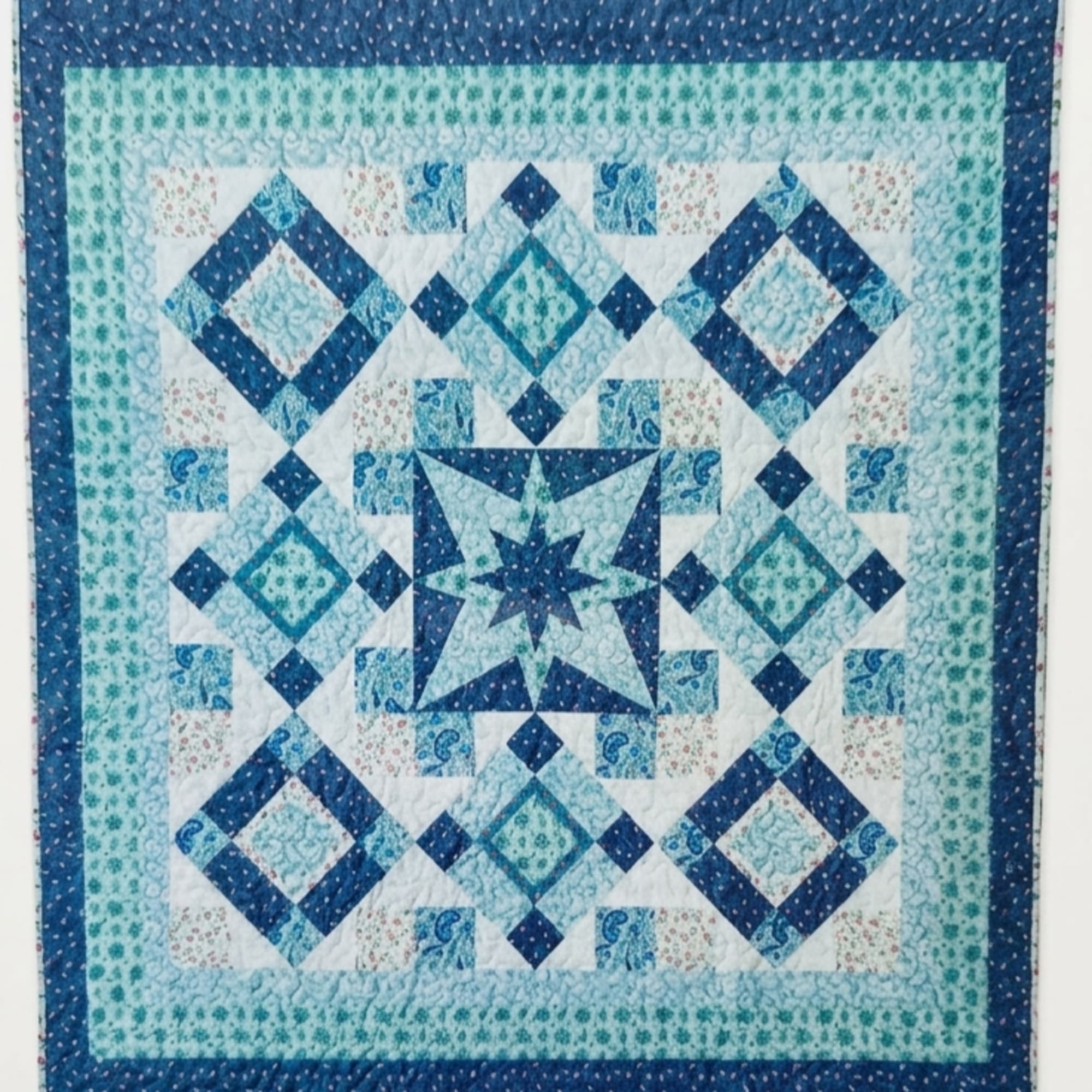 A cozy quilted throw in shades of navy, aqua, teal and white
