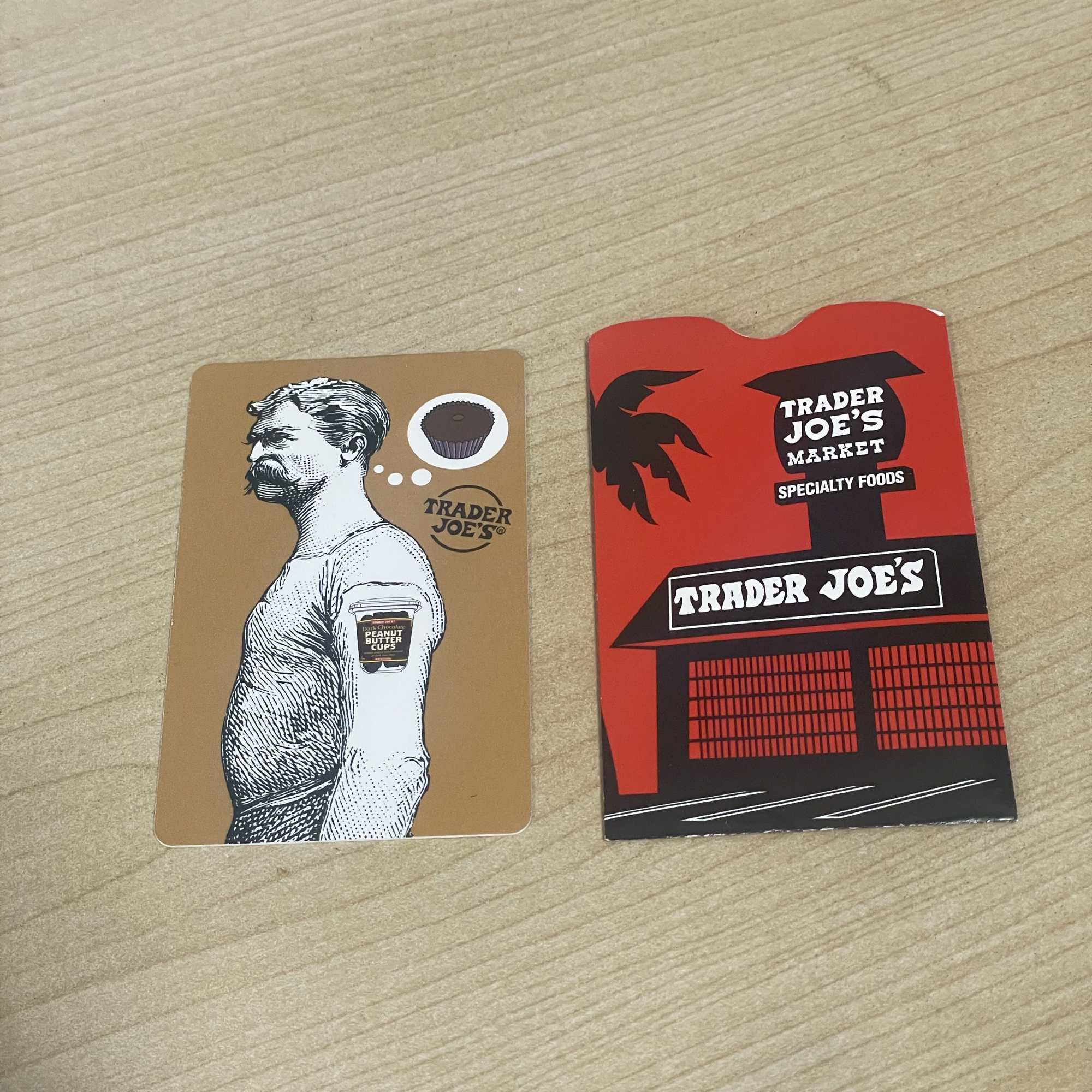 Two Trader Joe's gift cards on a wooden table
