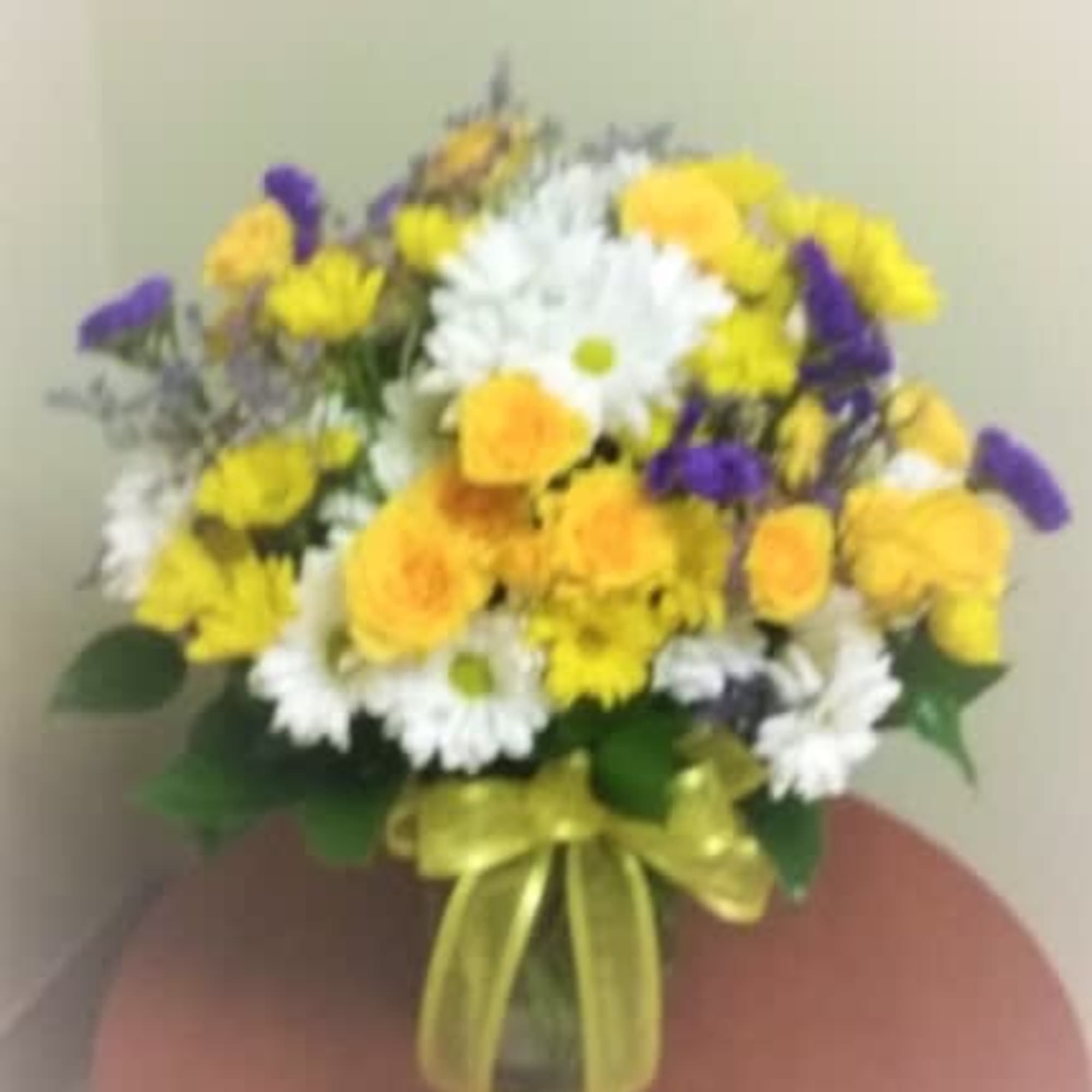 Surprise someone with daisies galore, miniature roses and purple statice for the