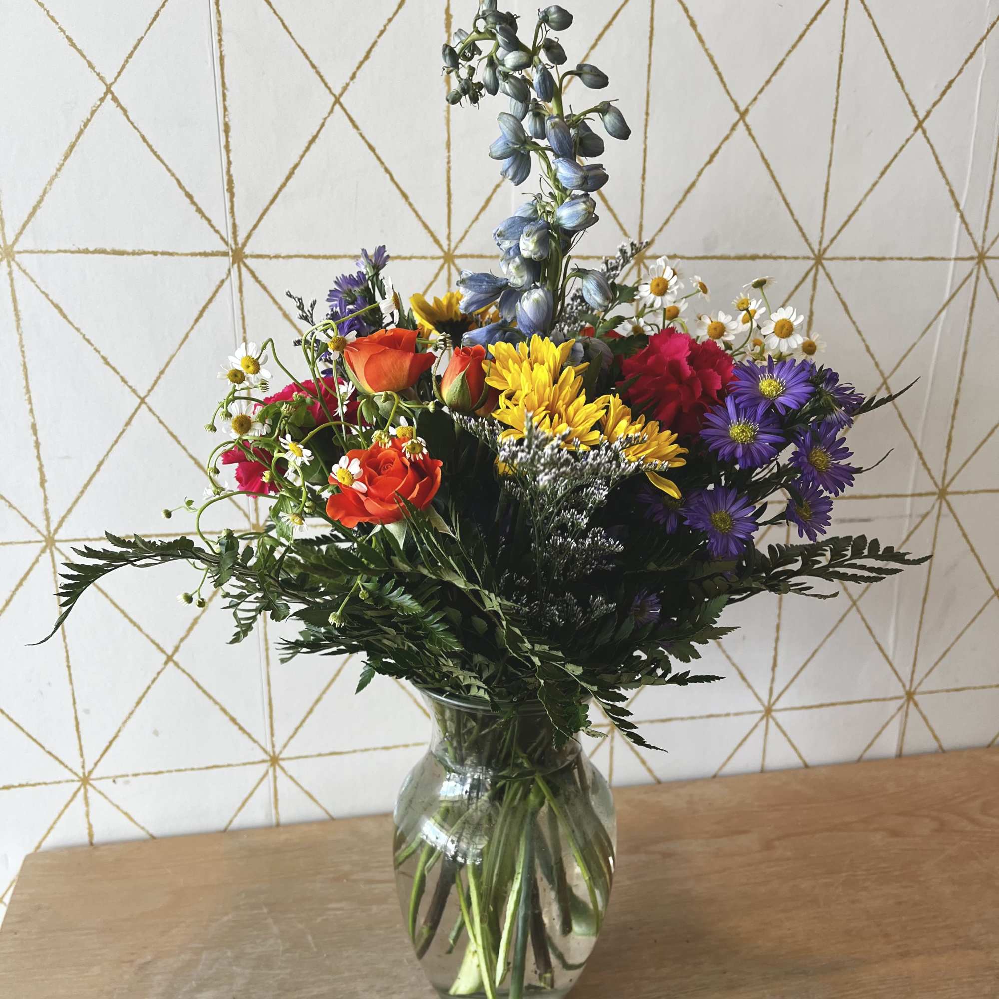 Mixed bouquet of colorful flowers in a clear glass vase