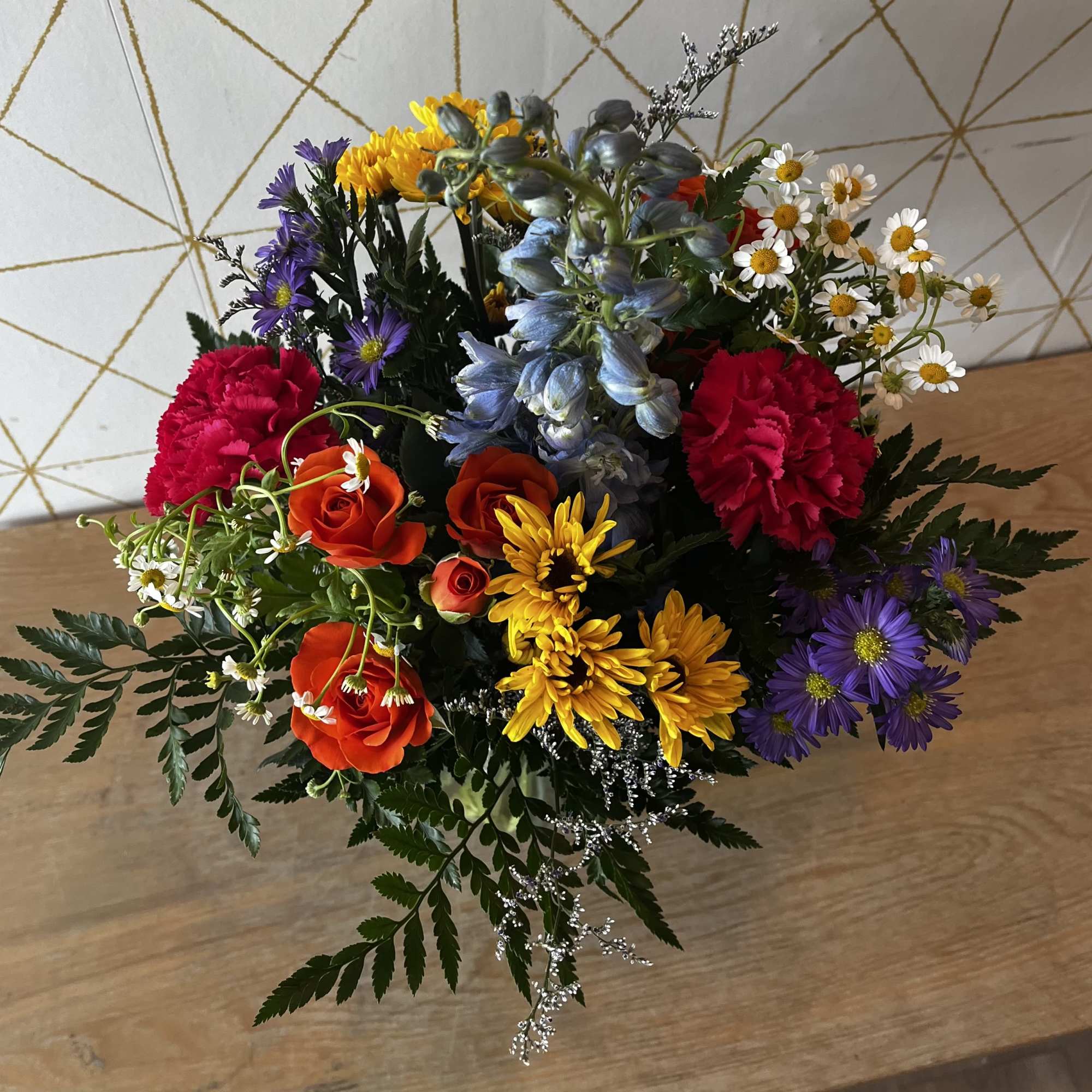Mixed bouquet with roses, carnations, daisies, and purple flowers