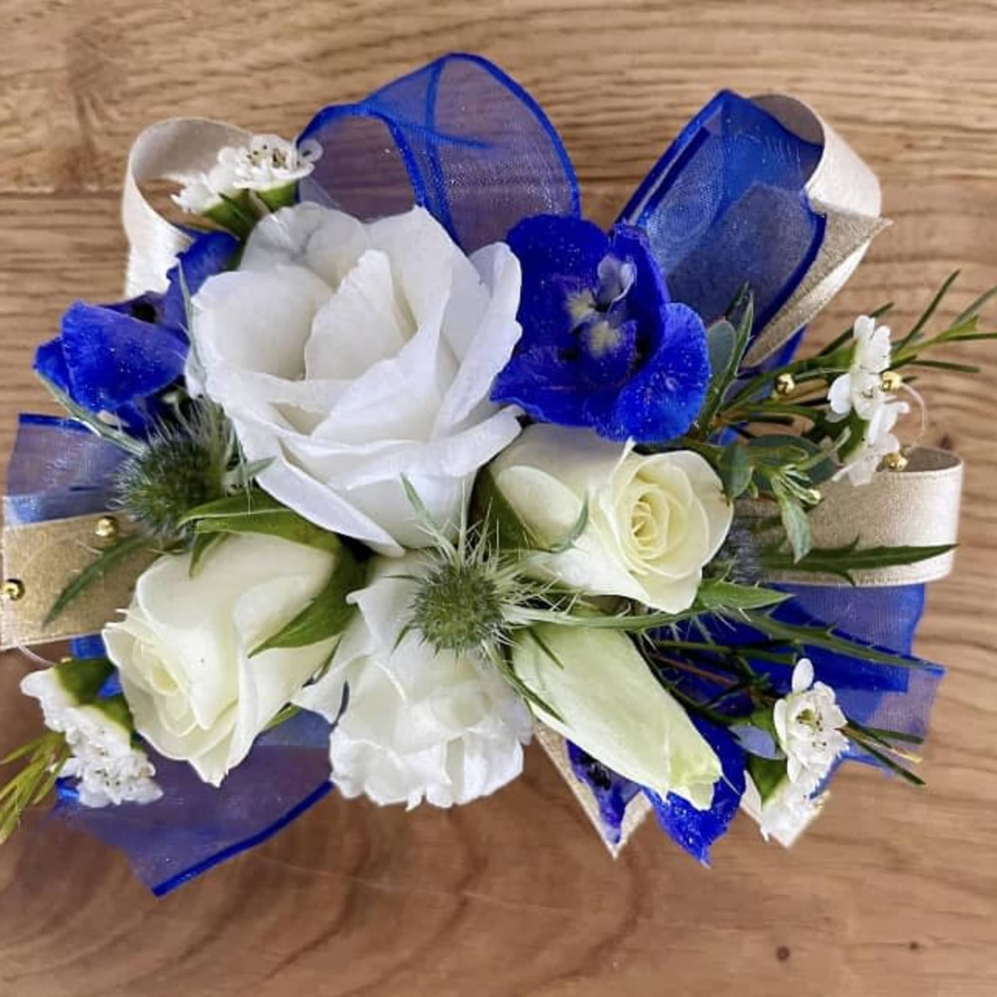 White and blue floral corsage with ribbon accents
