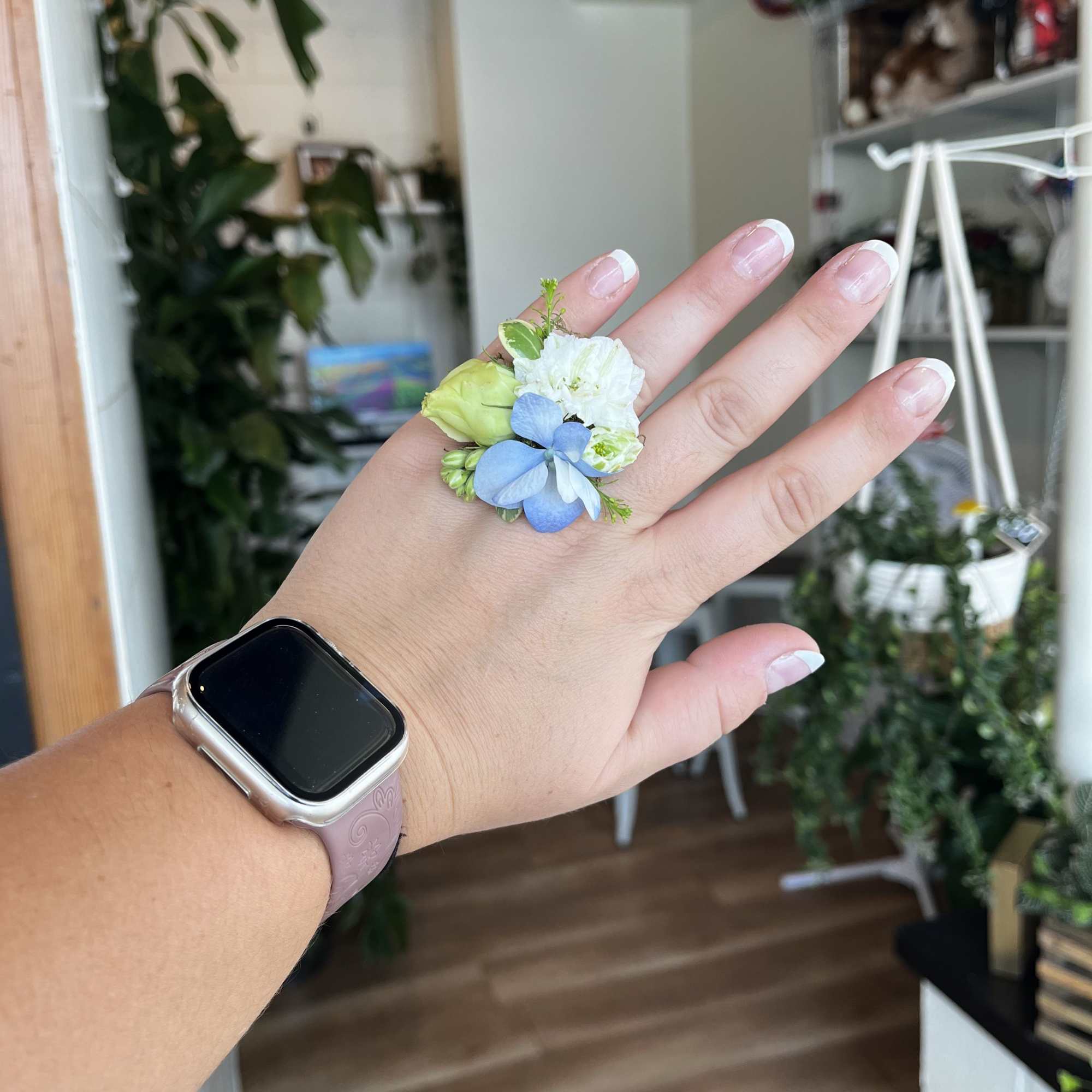 Small blue and white flower ring on a hand