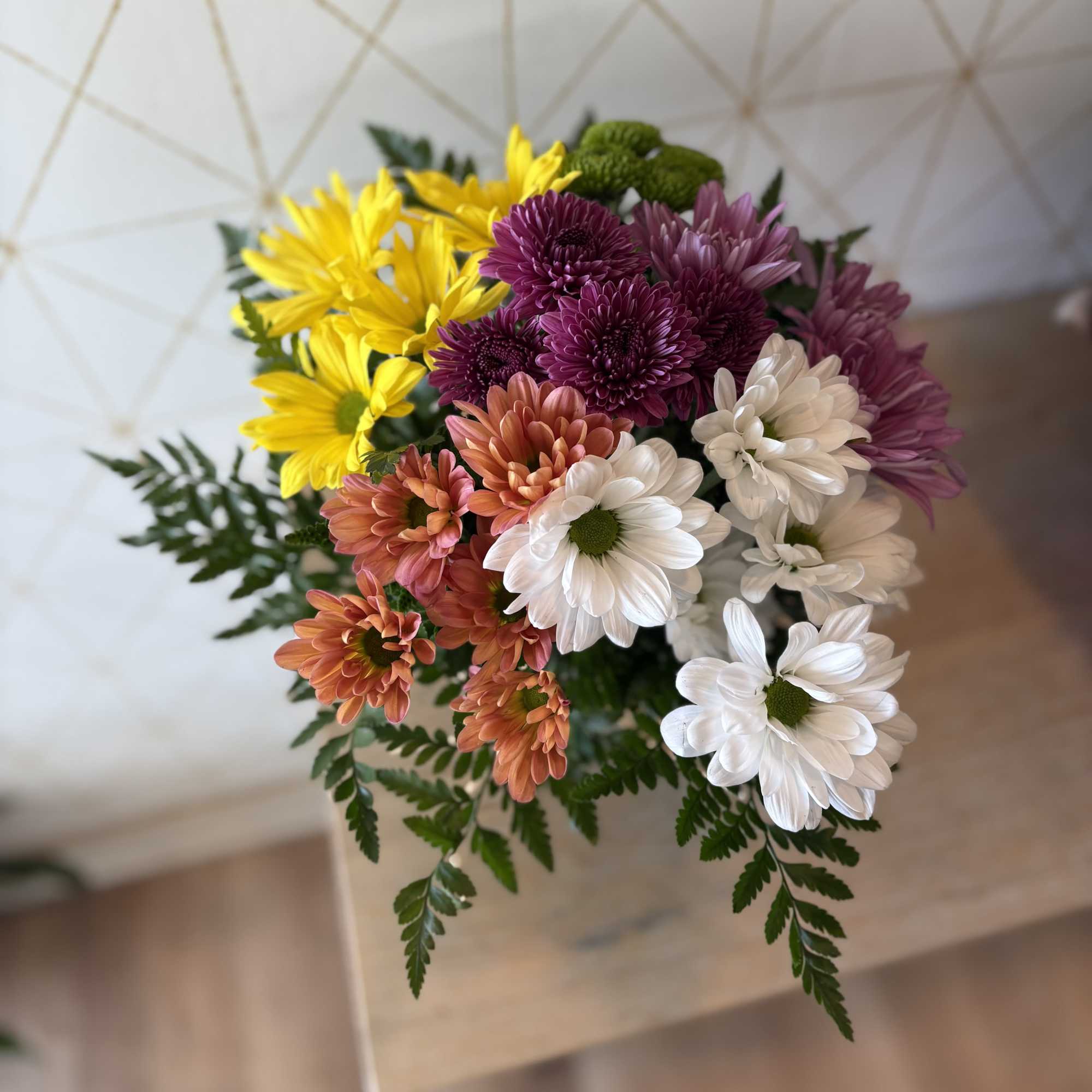Bouquet of multicolored daisies with fern foliage