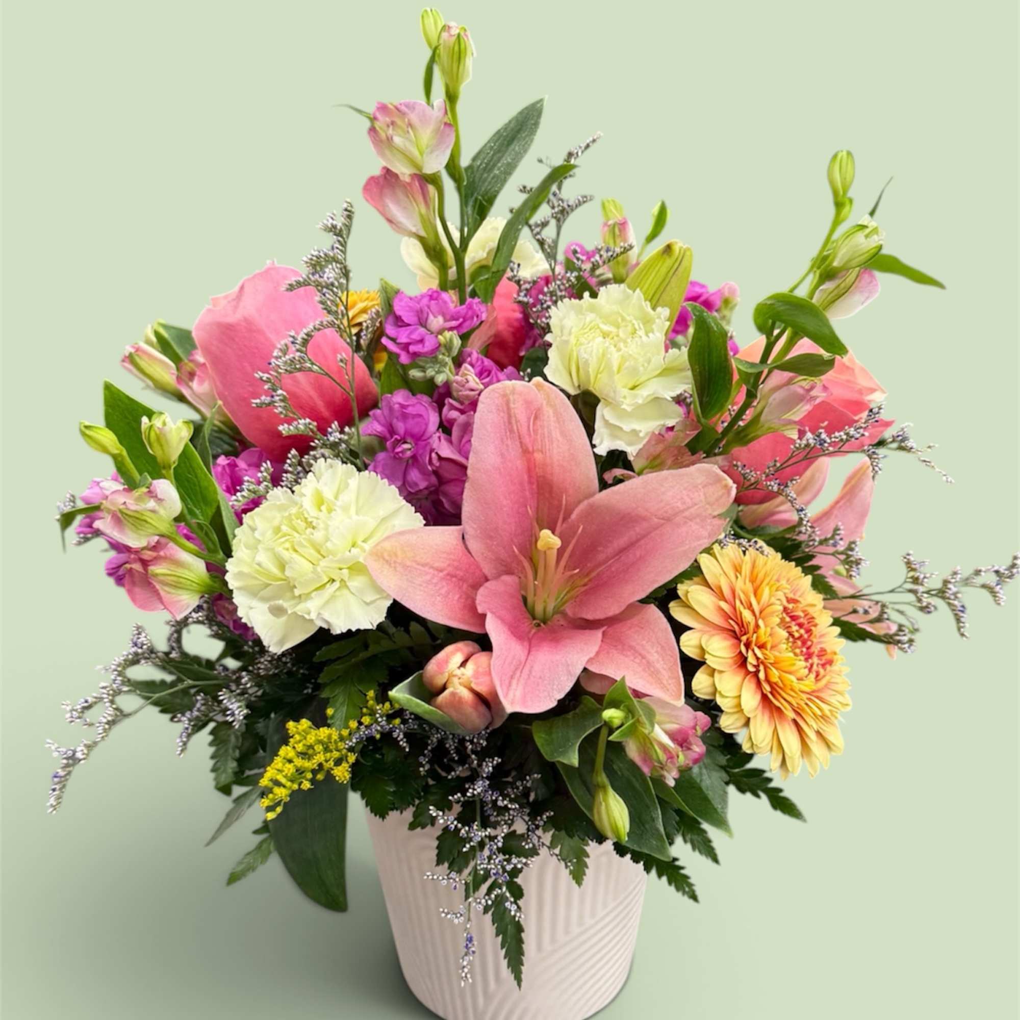 Pink and white mixed flower arrangement in a white vase