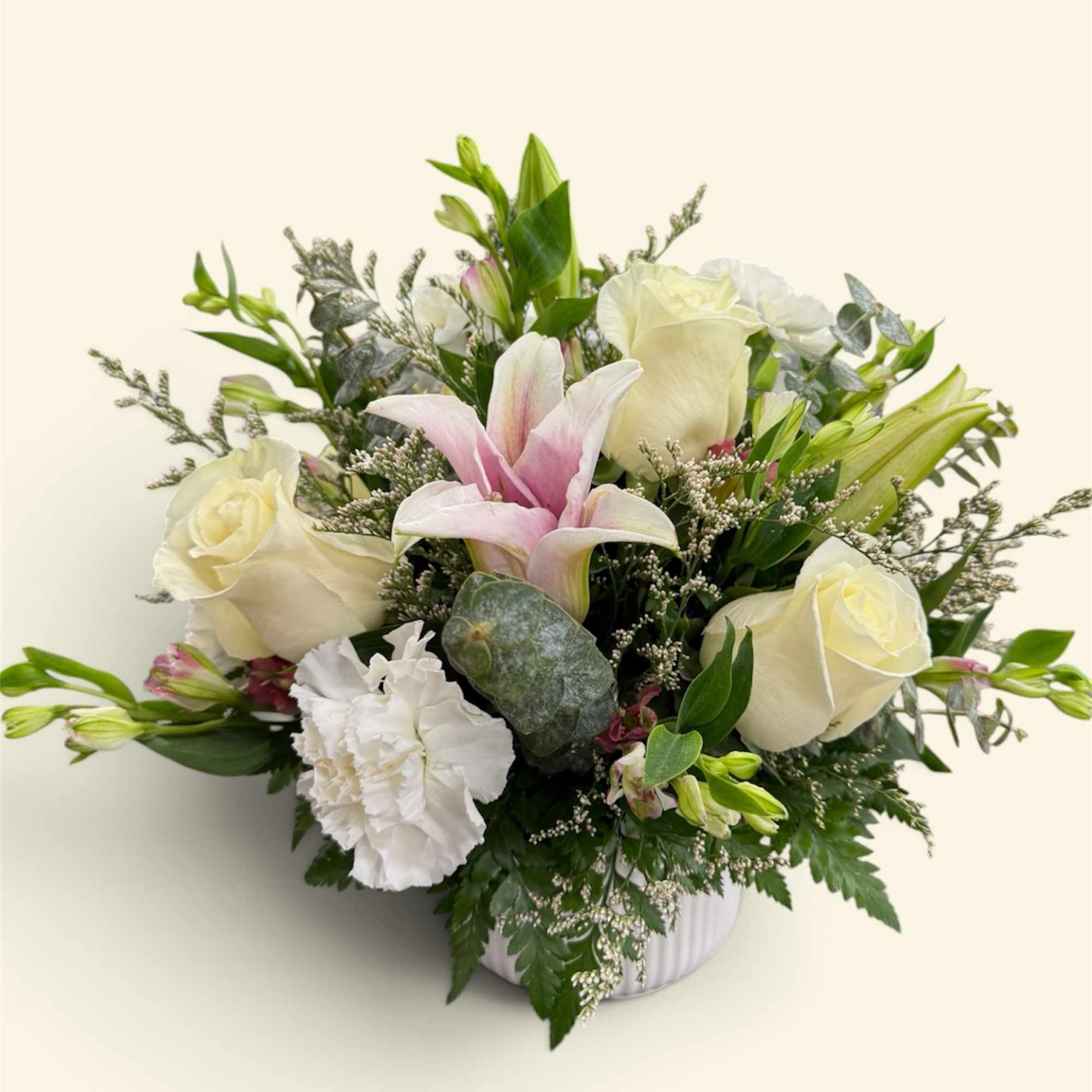 Bouquet of white roses, pink lilies, and white carnations in a vase