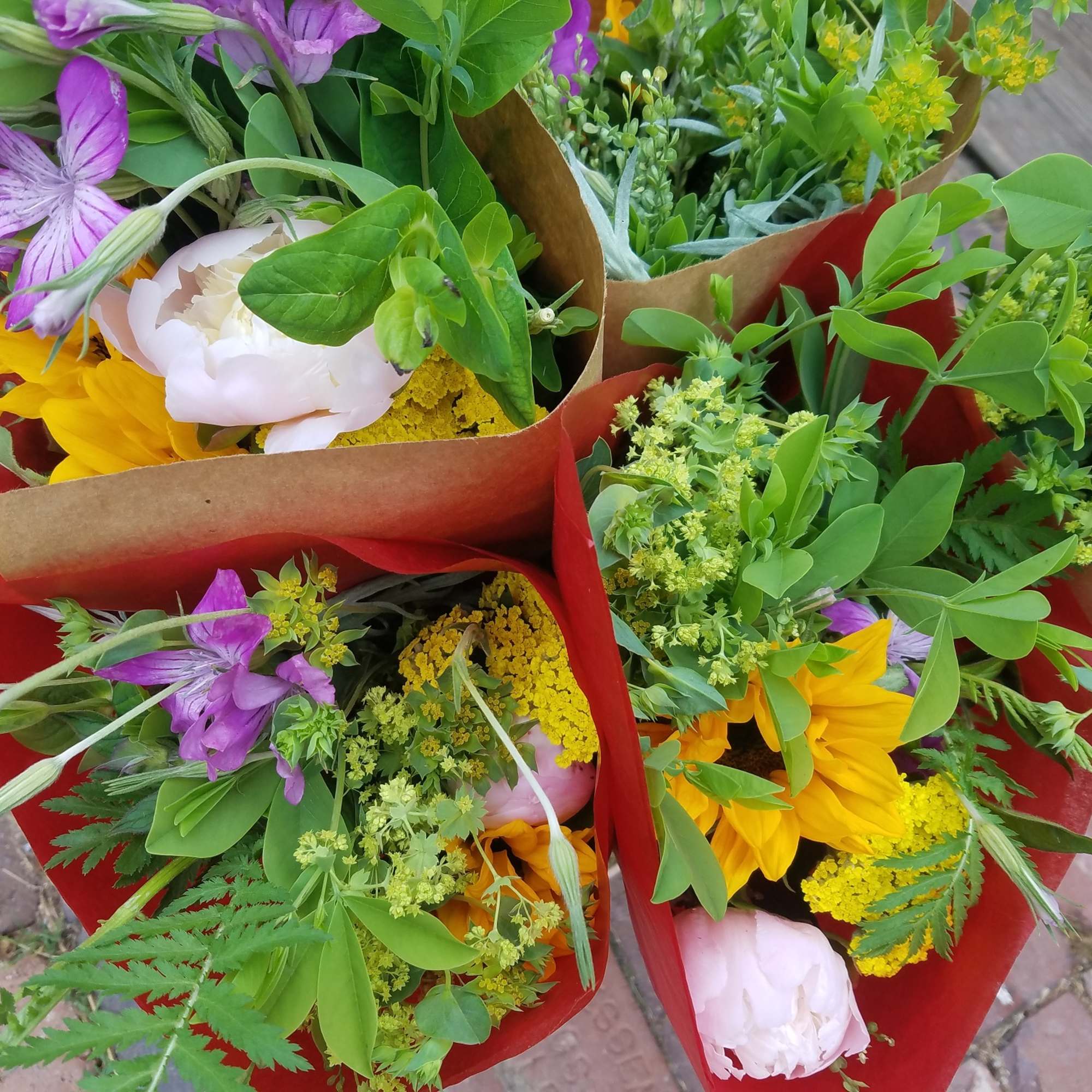 Several wrapped bouquets with purple, yellow, and white flowers