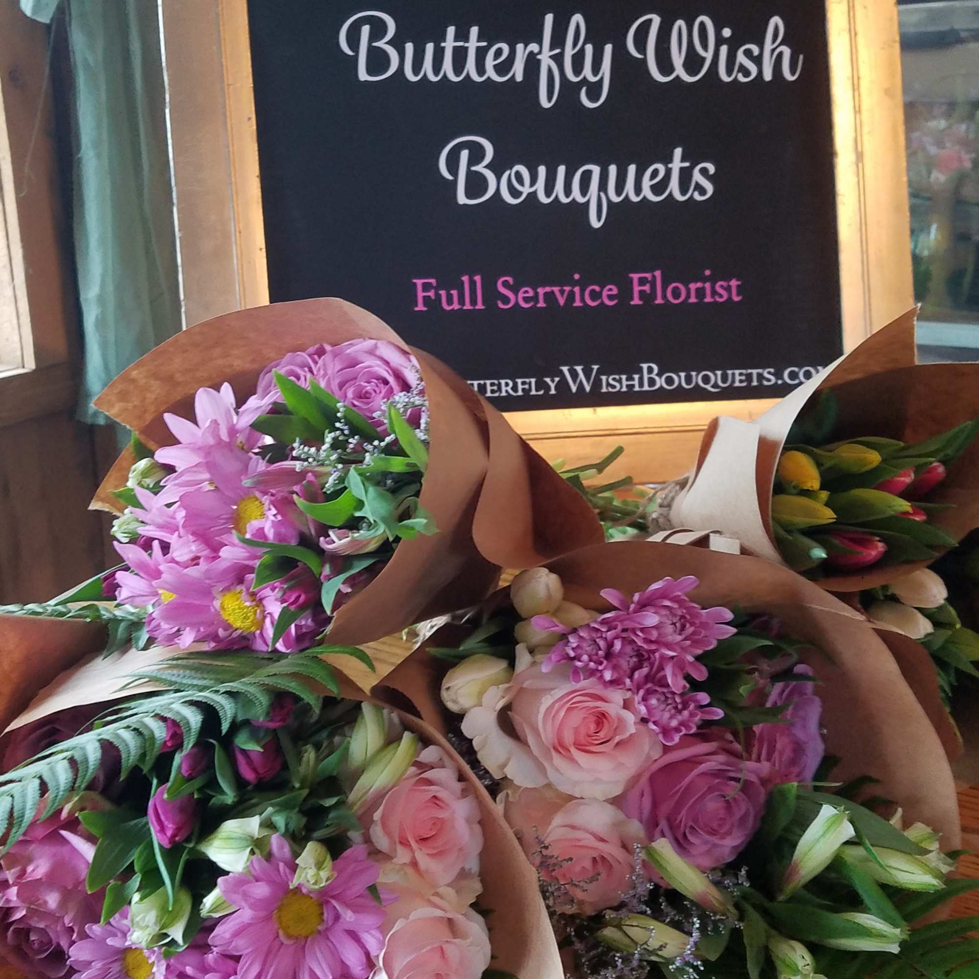 Assorted pink flower bouquets wrapped in brown paper