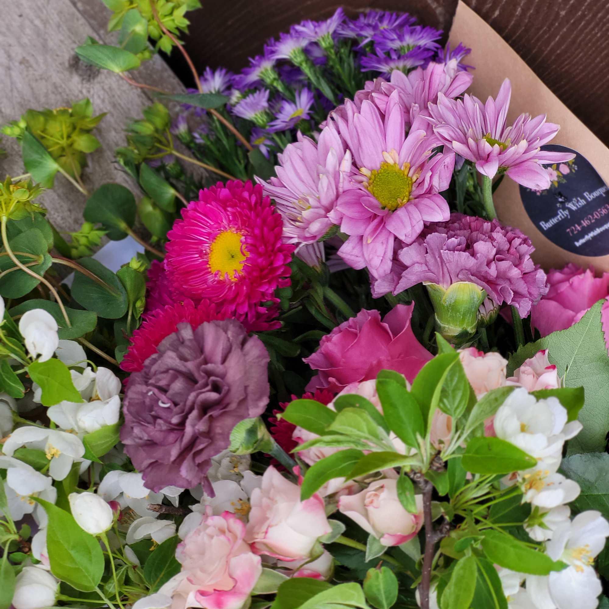 Mixed bouquet of pink, purple, and white flowers with green foliage