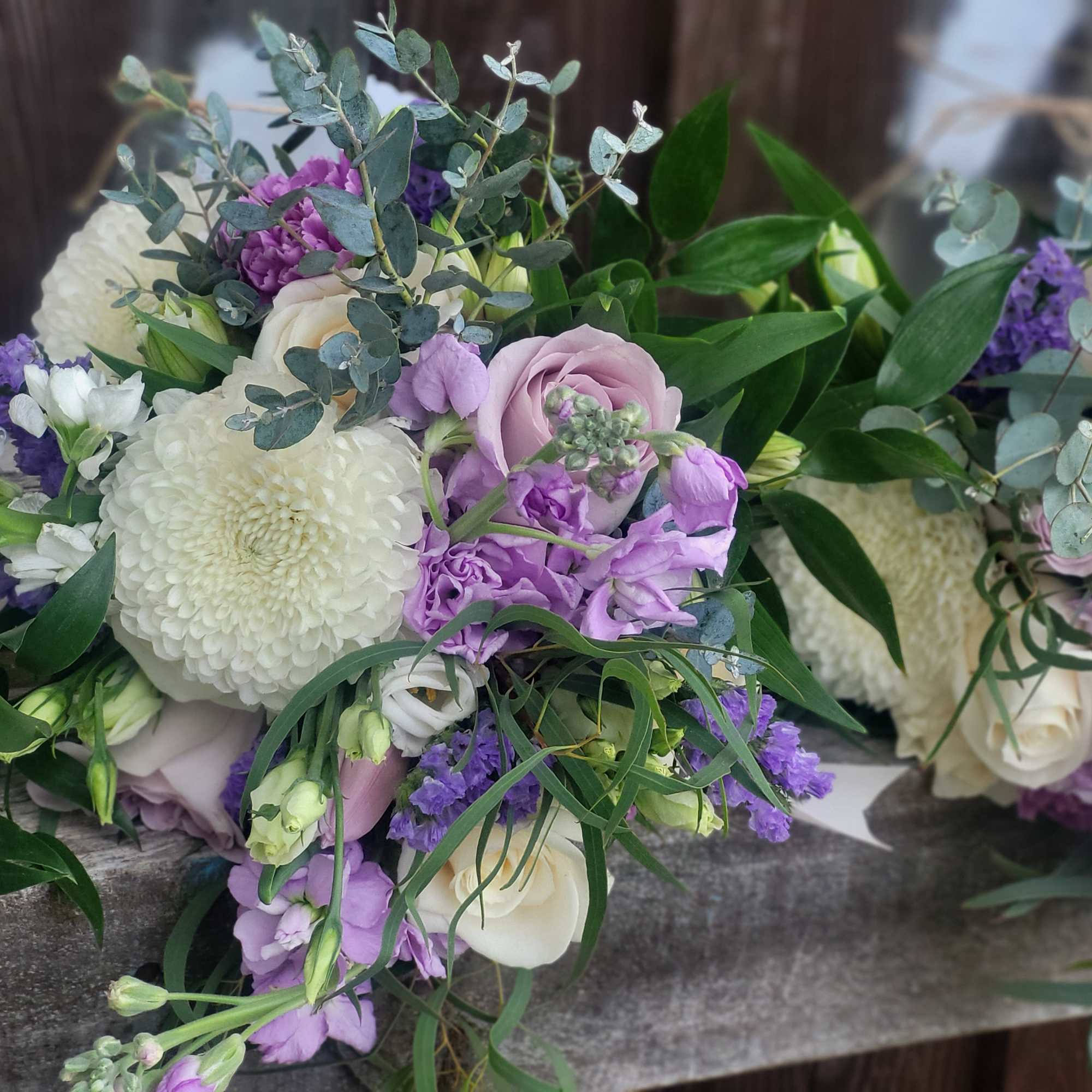 Bouquets of white and lavender flowers with greenery
