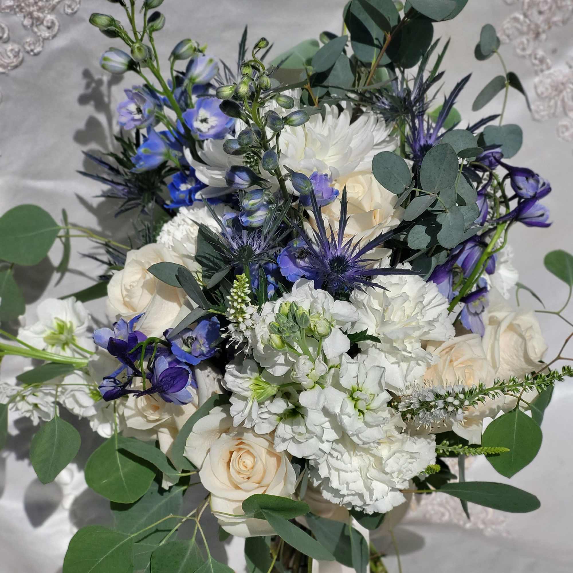 Bouquet of white and blue flowers with eucalyptus greenery
