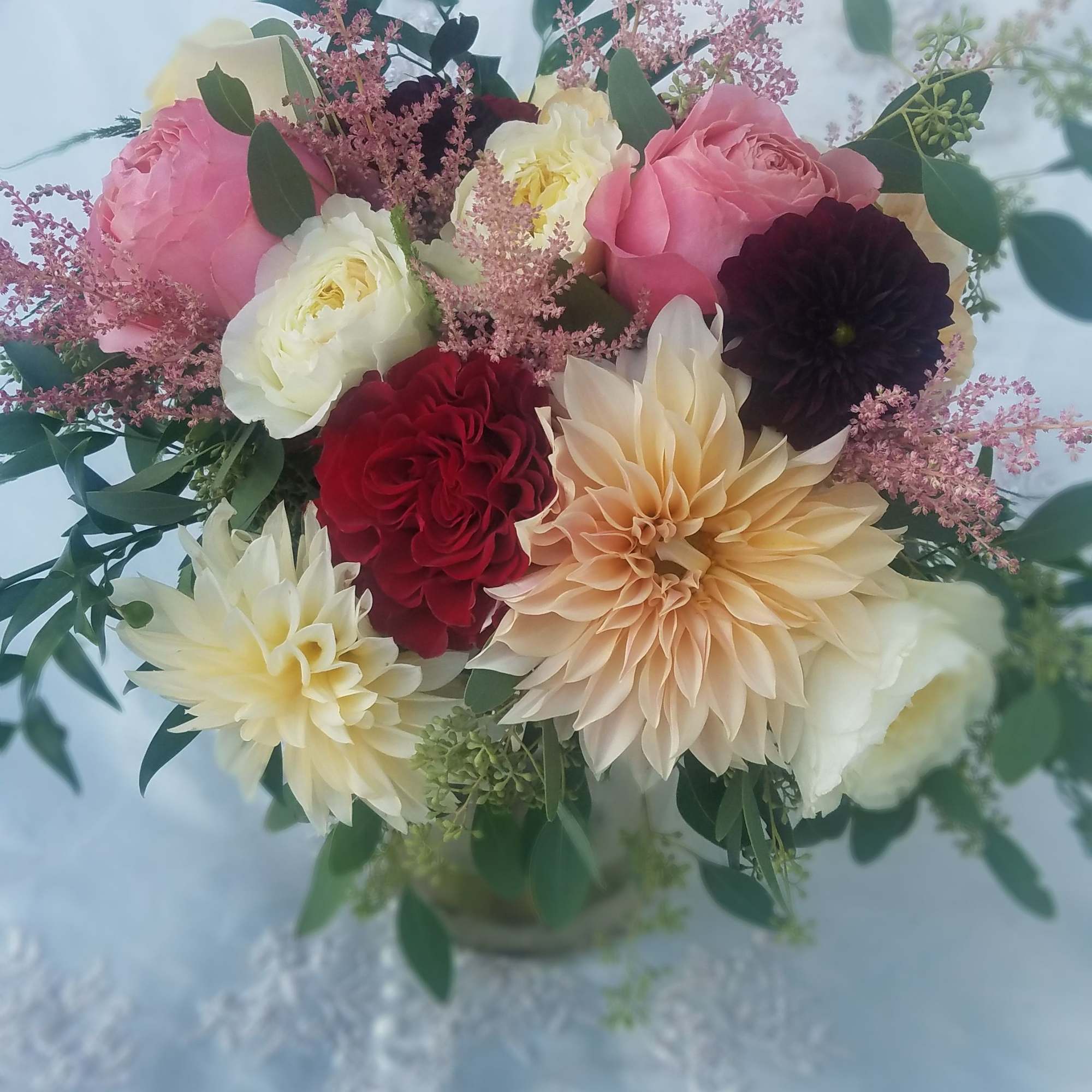 Bouquet of pink, white, red, and peach flowers with greenery