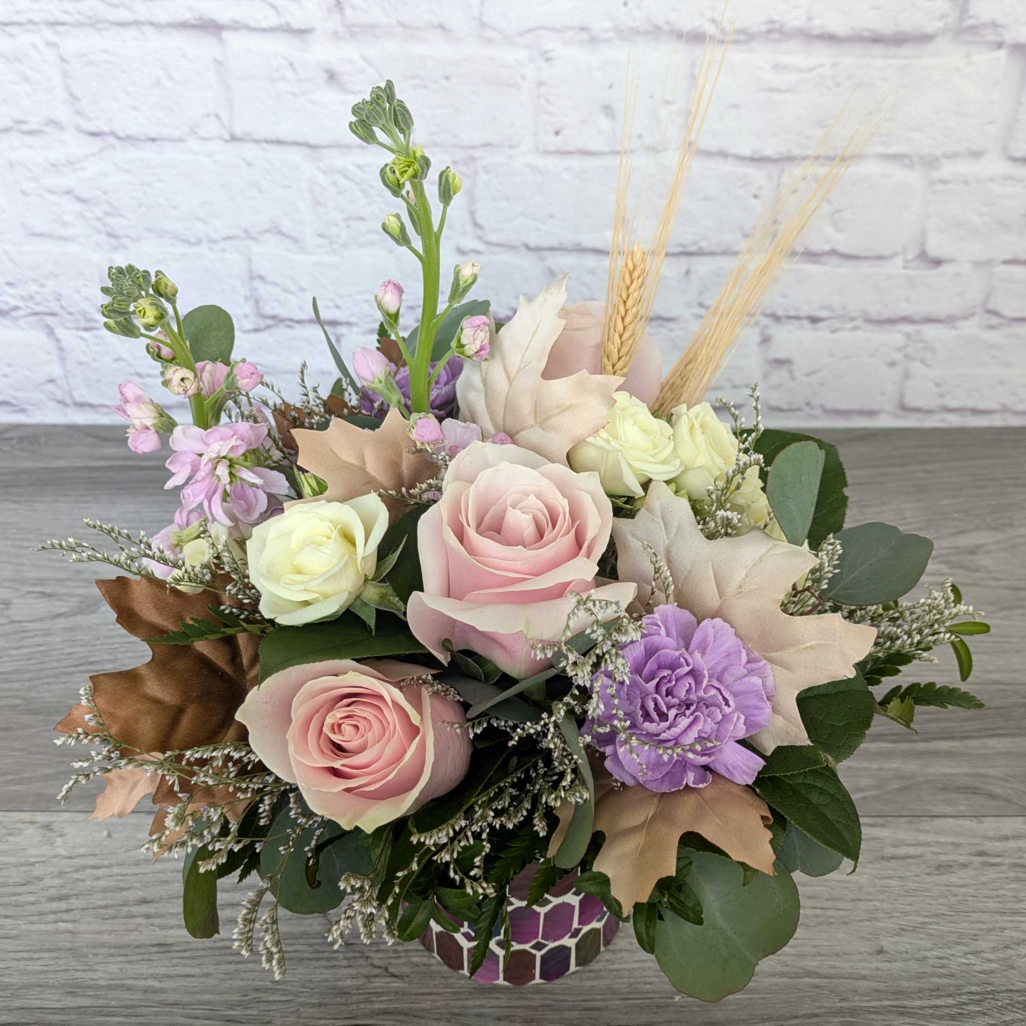 Pastel rose and carnation bouquet in a patterned vase