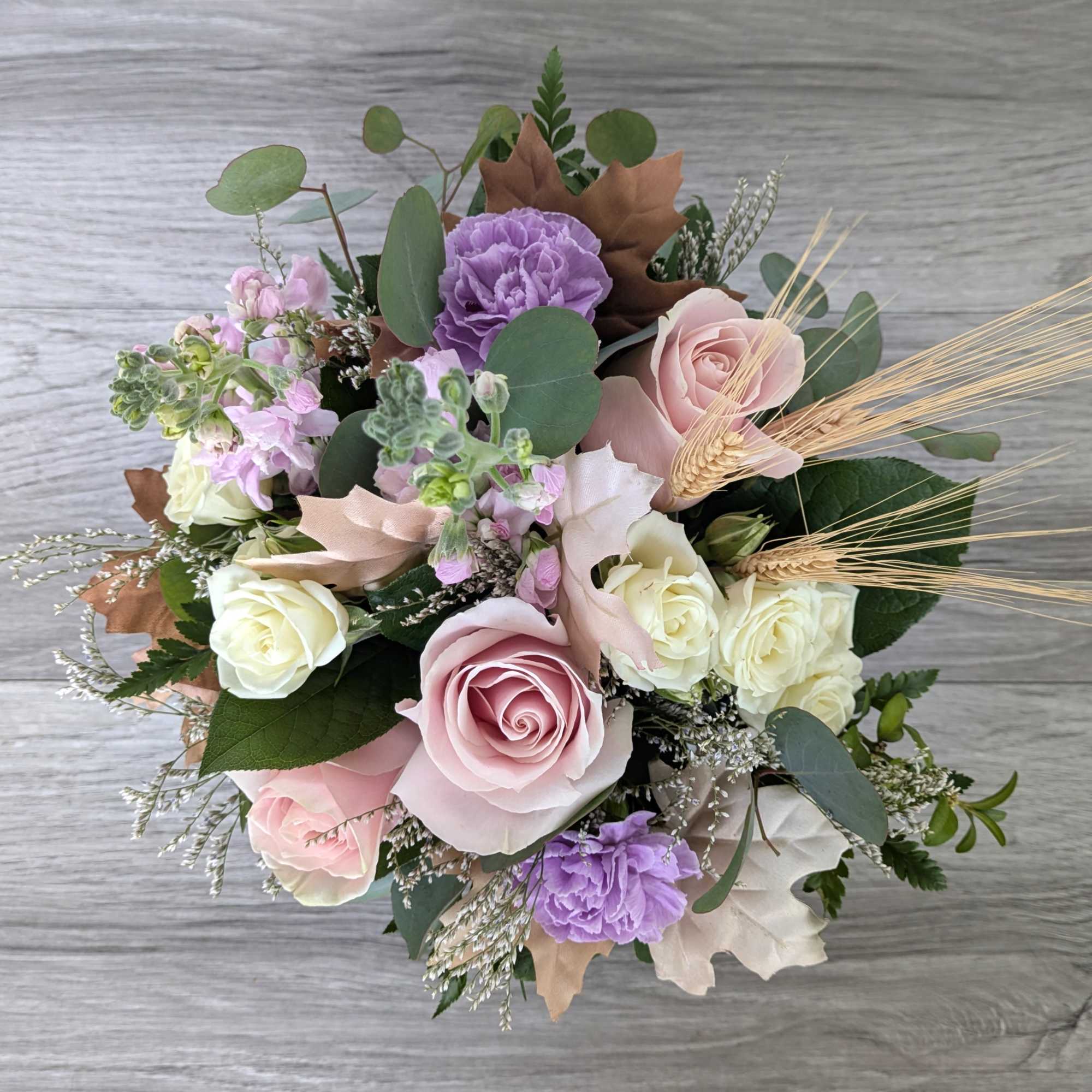 Bouquet of pink, white, and purple flowers with dried wheat accents
