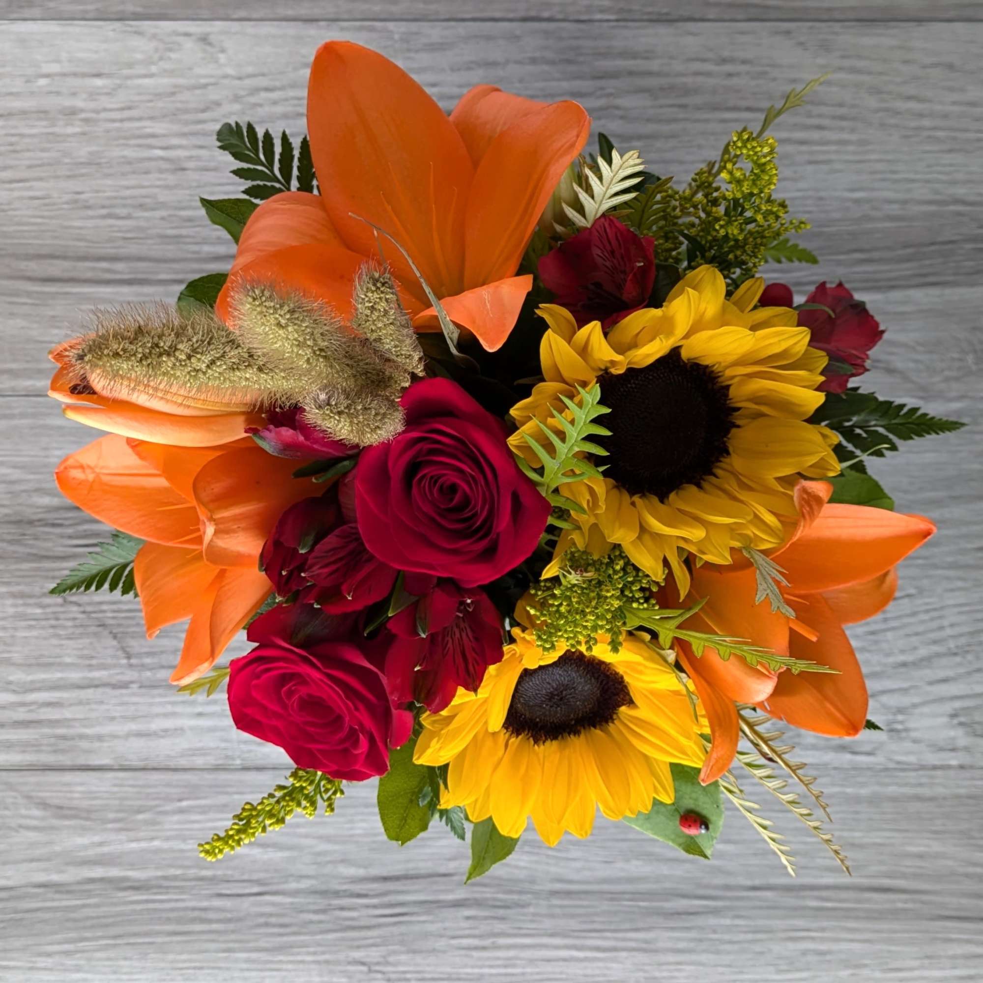 Bouquet of orange lilies, yellow sunflowers, and red roses