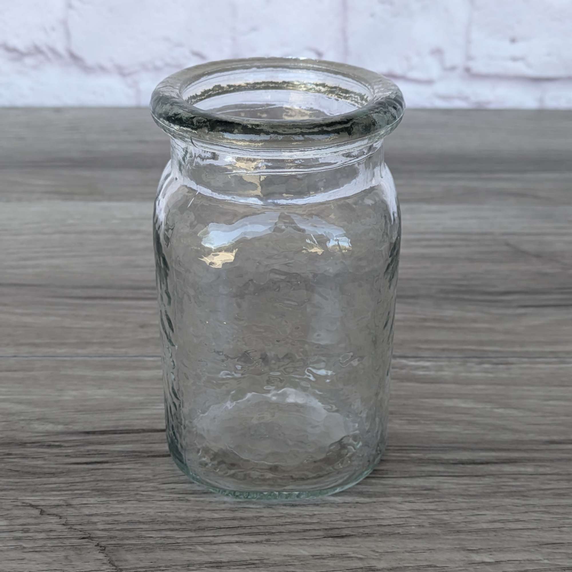 Clear textured glass vase on a wooden surface