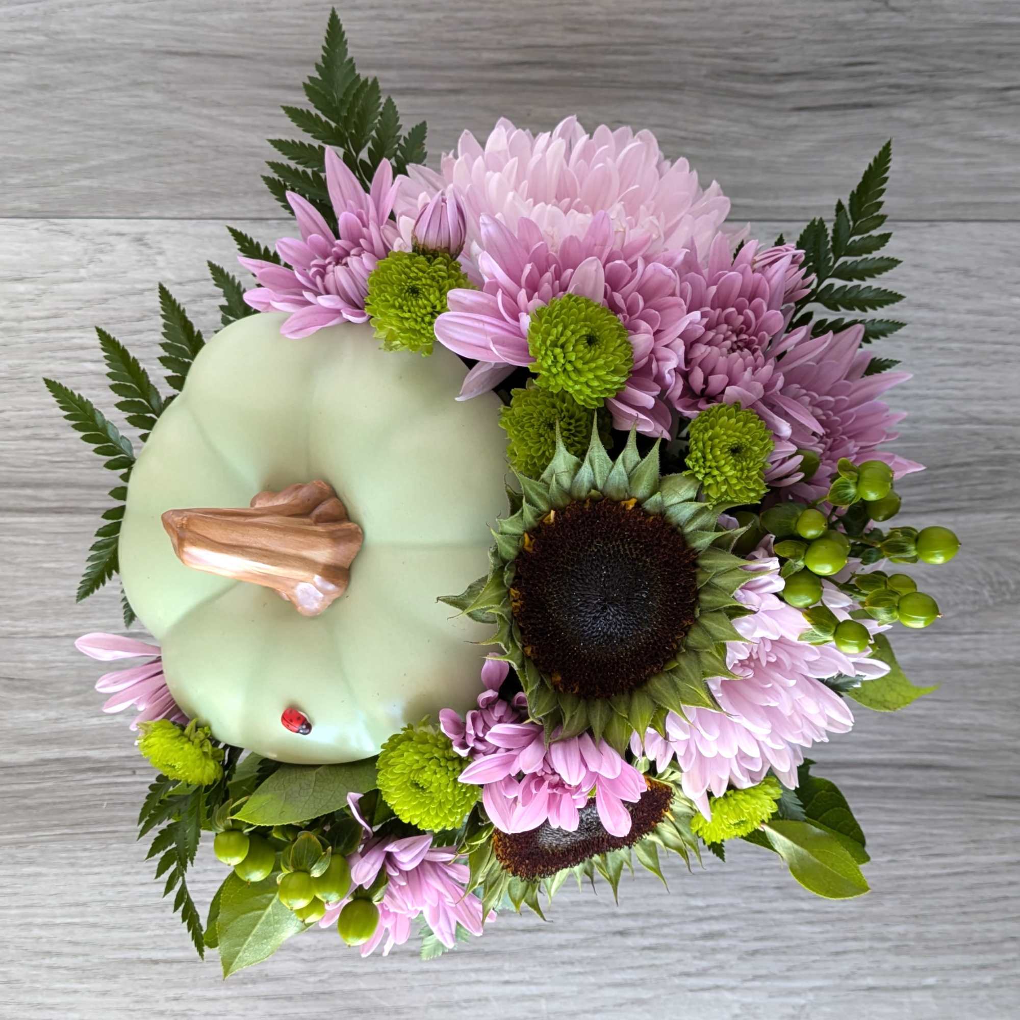 Pumpkin-shaped floral arrangement with pink and green flowers