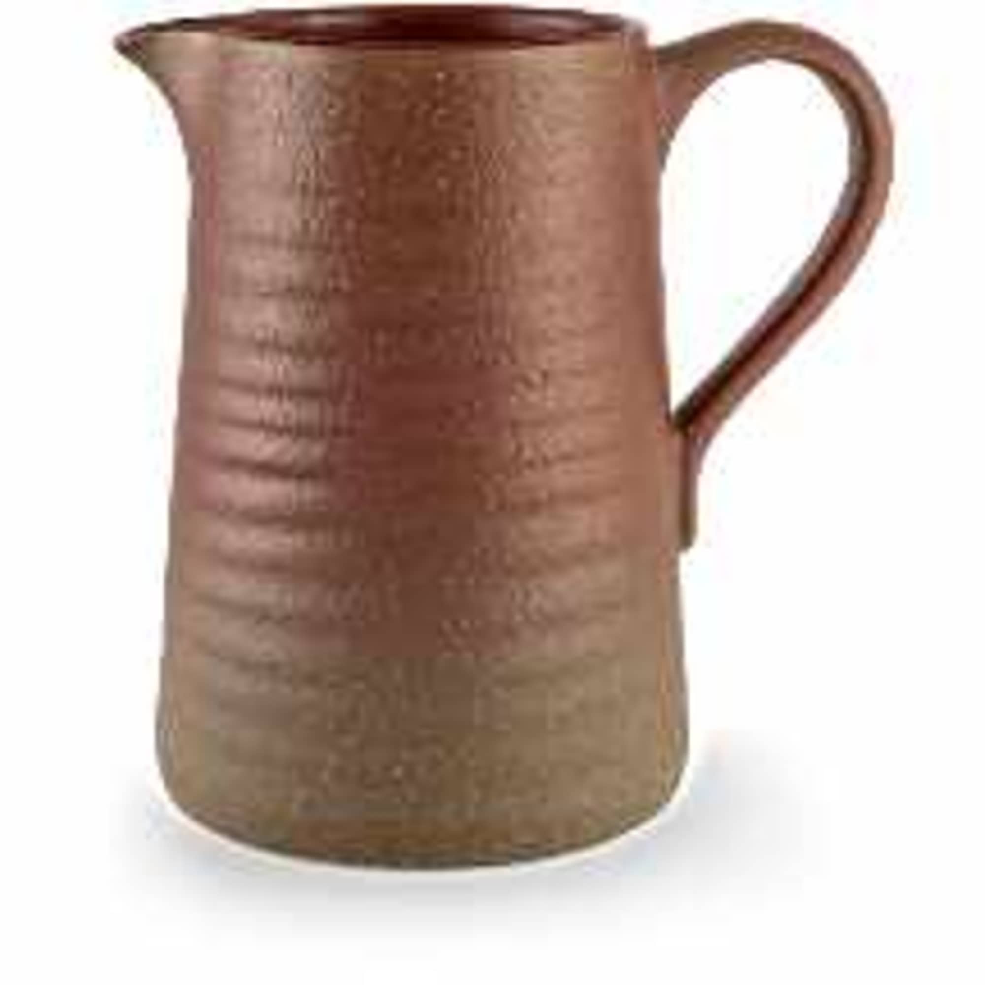 Copper-colored metal pitcher with a handle on a white background