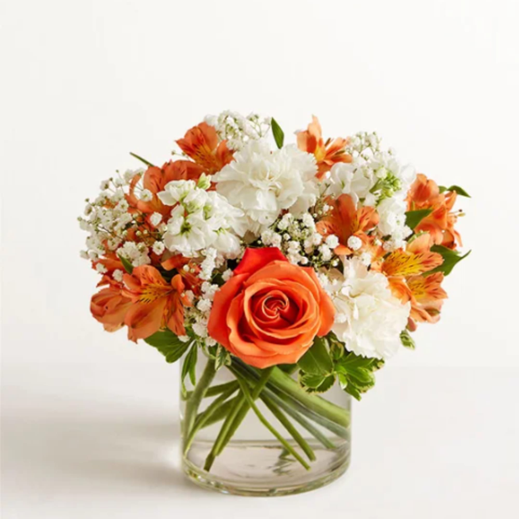 Orange and white mixed flower bouquet in a clear glass vase