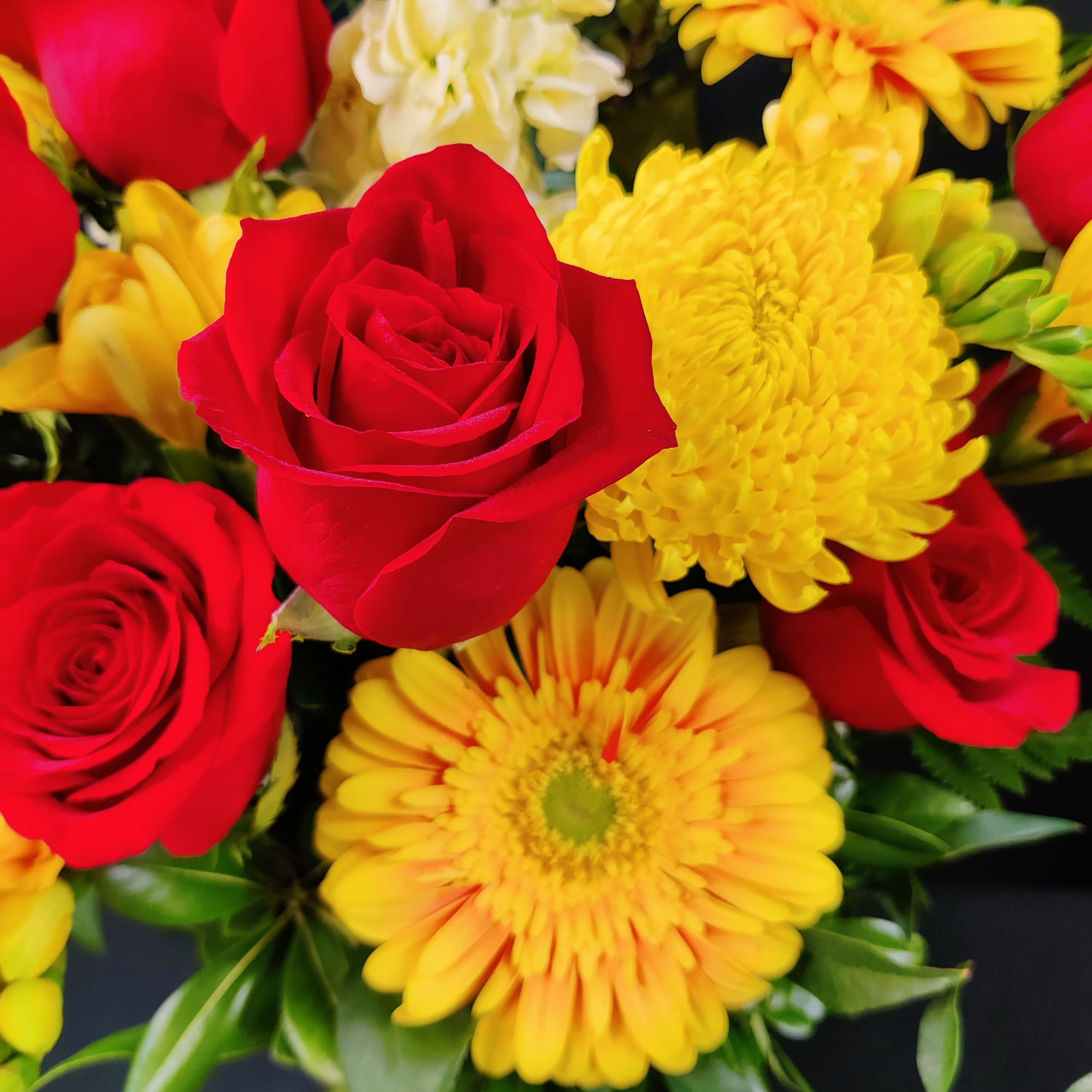 Red roses and yellow daisies in a bouquet