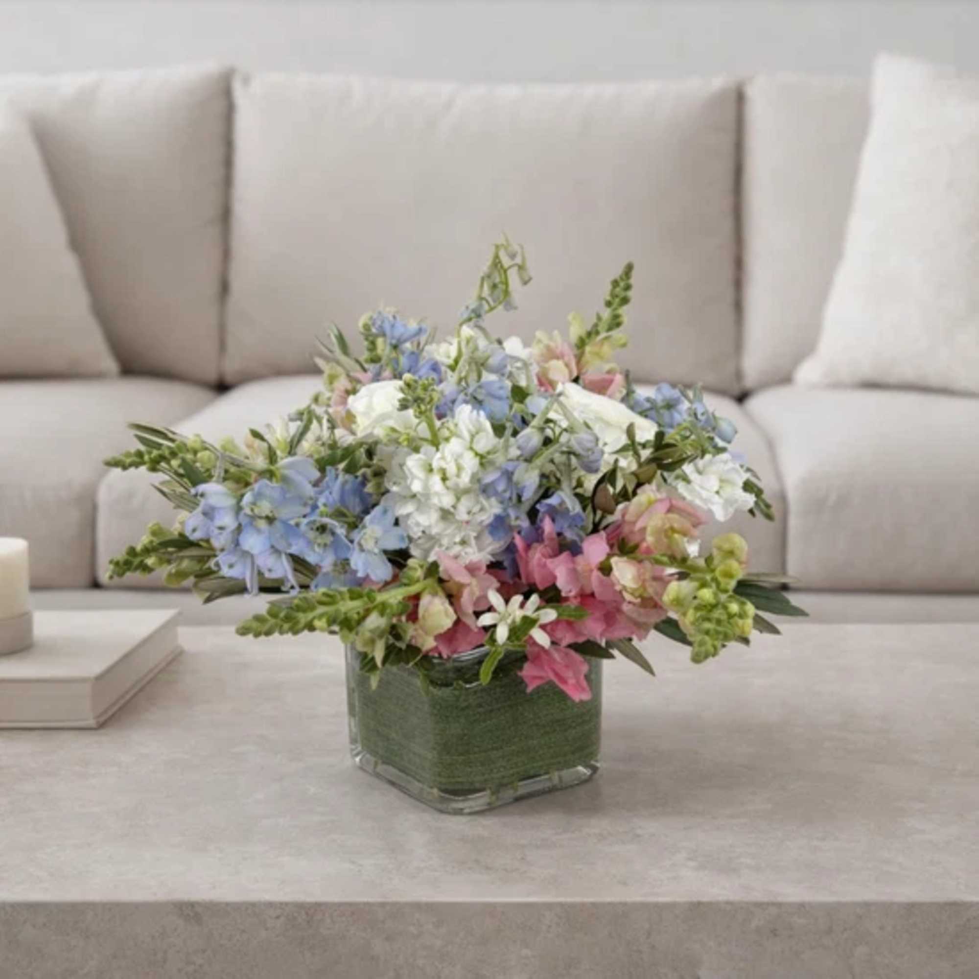 Pastel mixed flower arrangement in a square glass vase