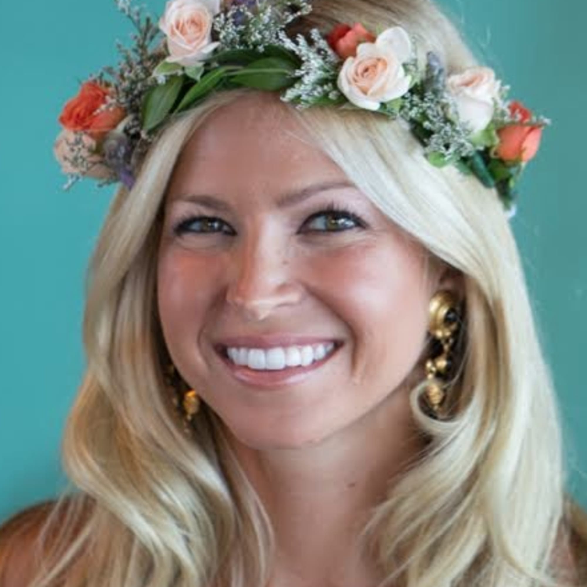 Woman wearing a floral crown of pale roses and orange blossoms