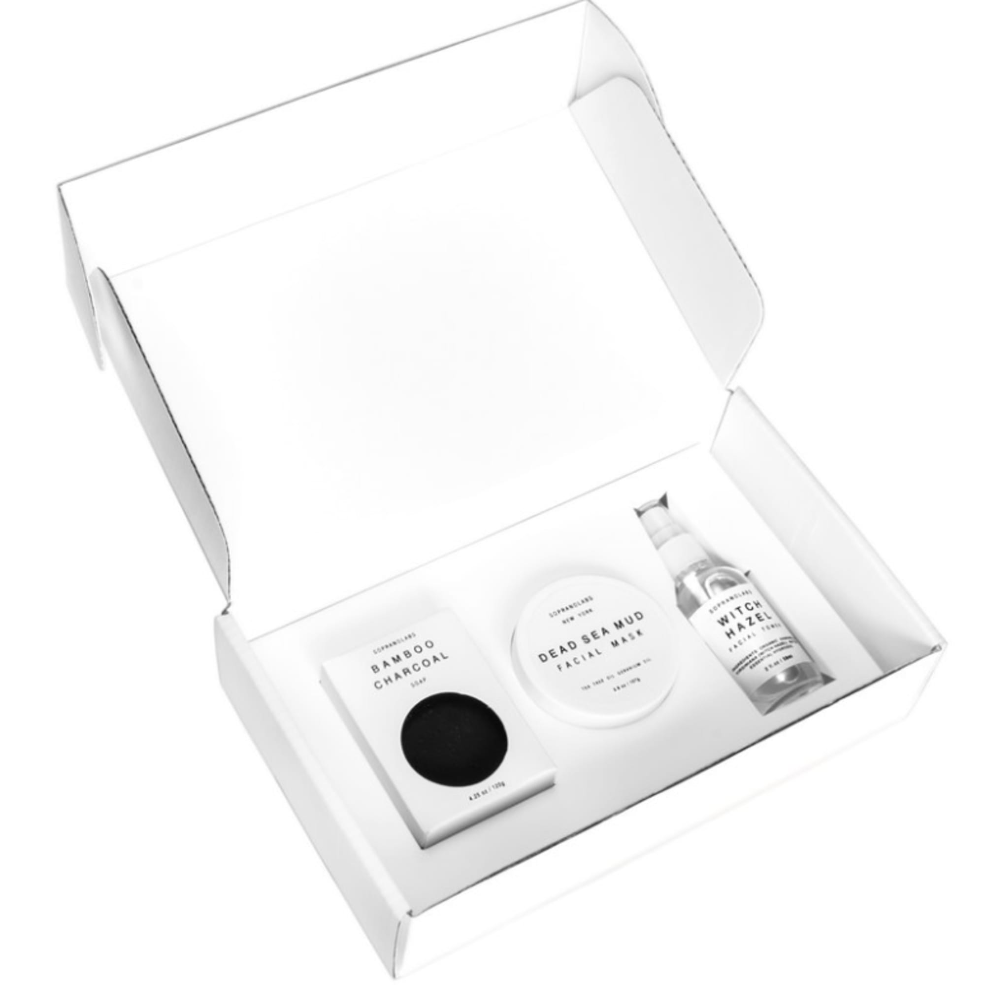 Open white gift box with three skincare products inside