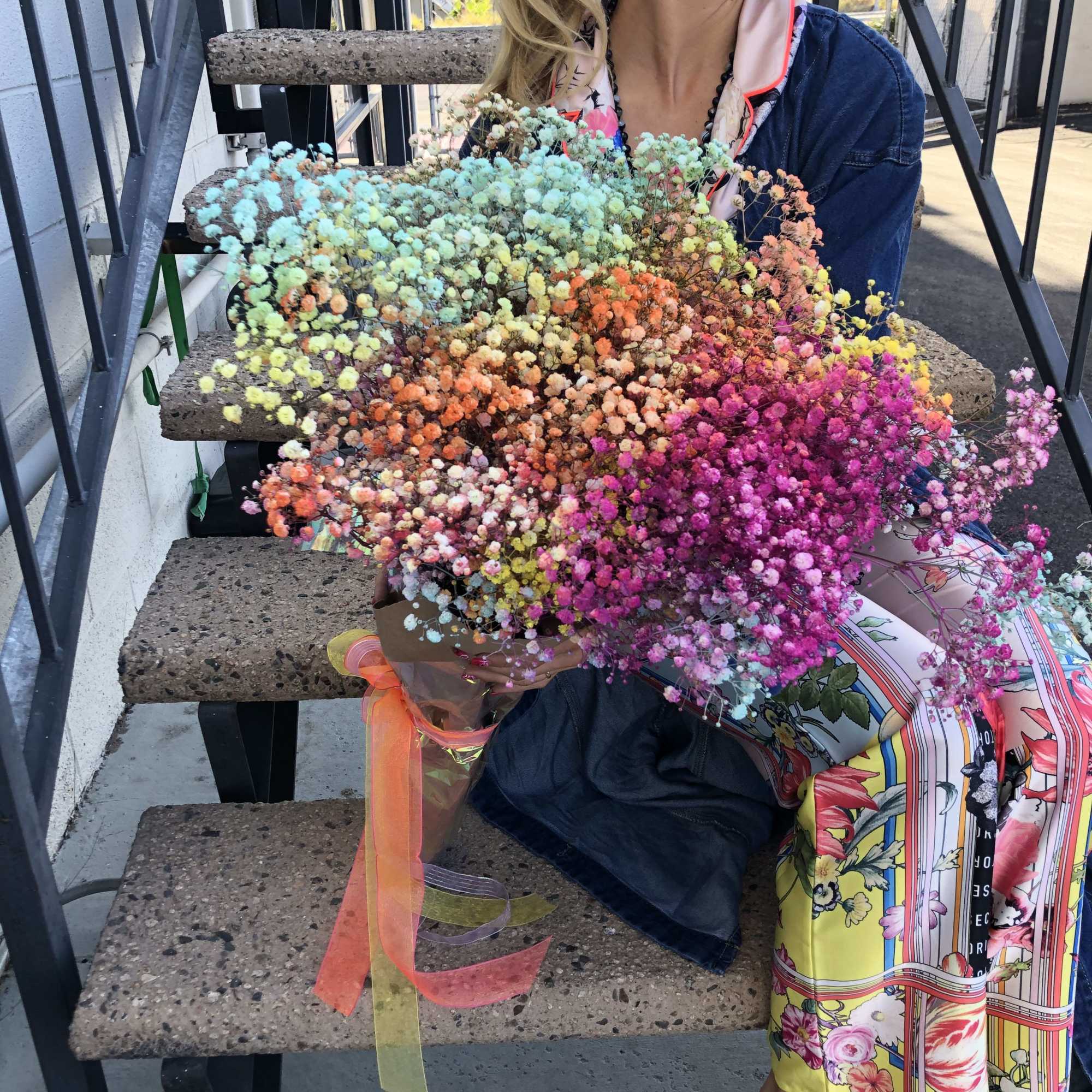 Woman holding a large multicolored bouquet of baby's breath