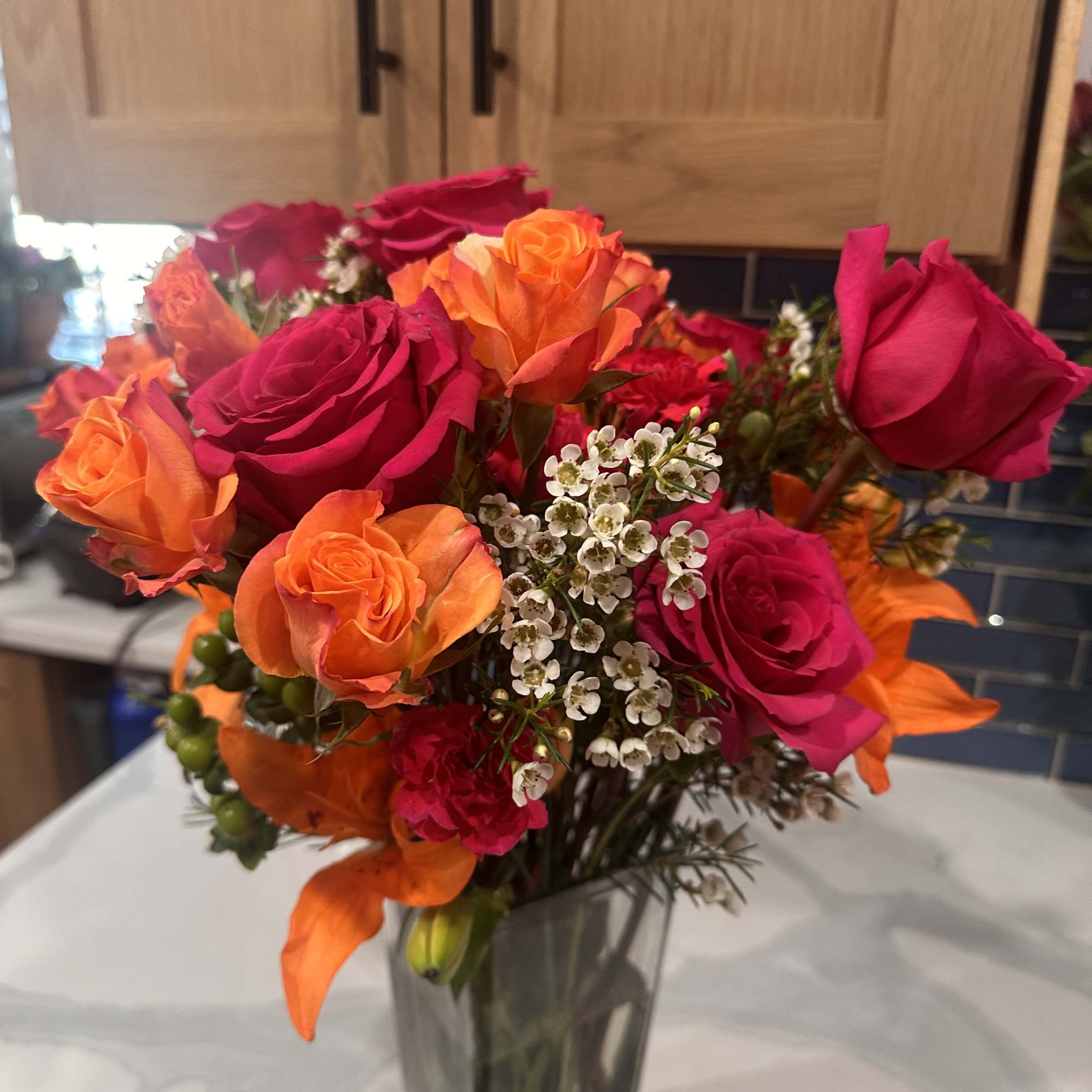 Bouquet of pink and orange roses in a clear glass vase