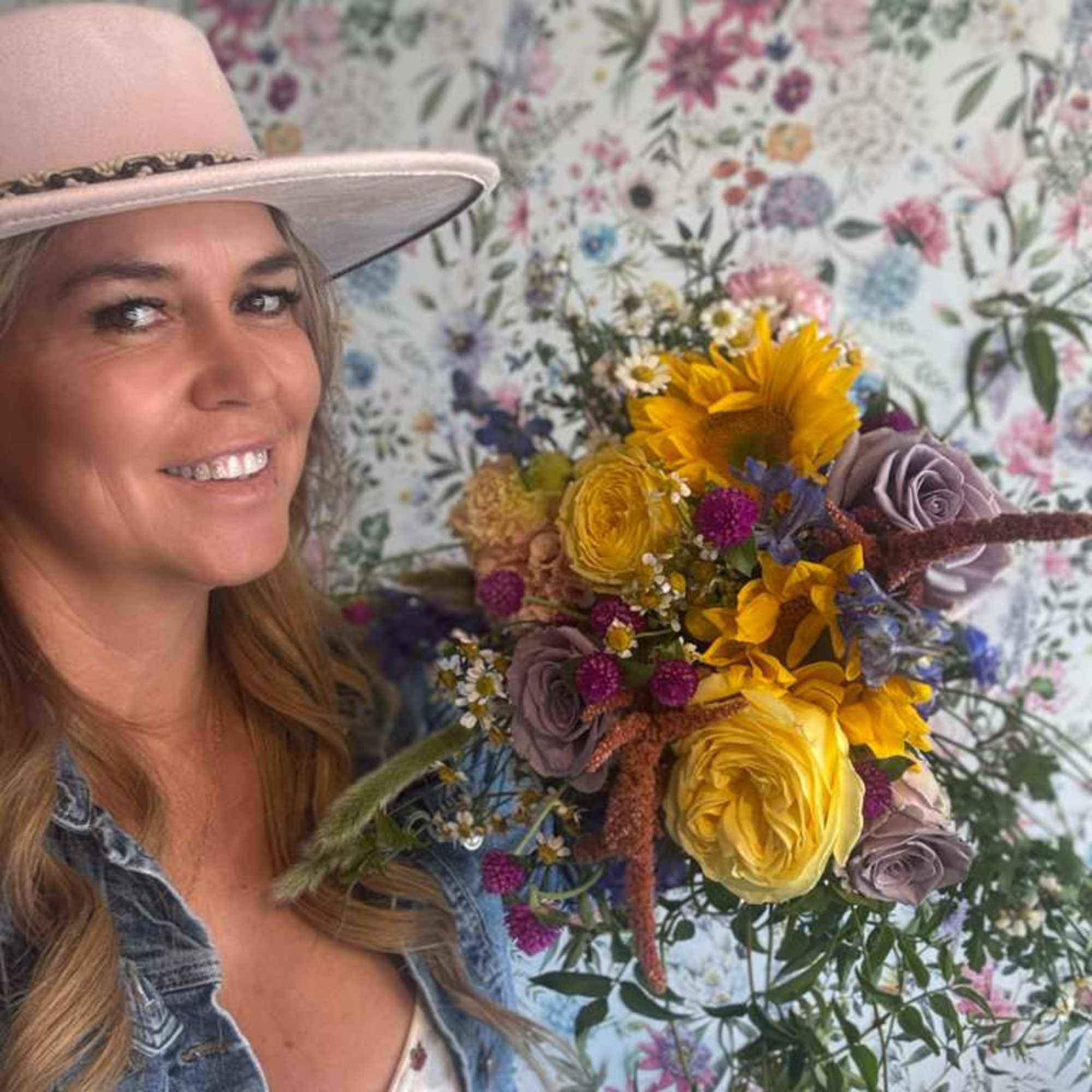 Woman holding a colorful bouquet with sunflowers and roses