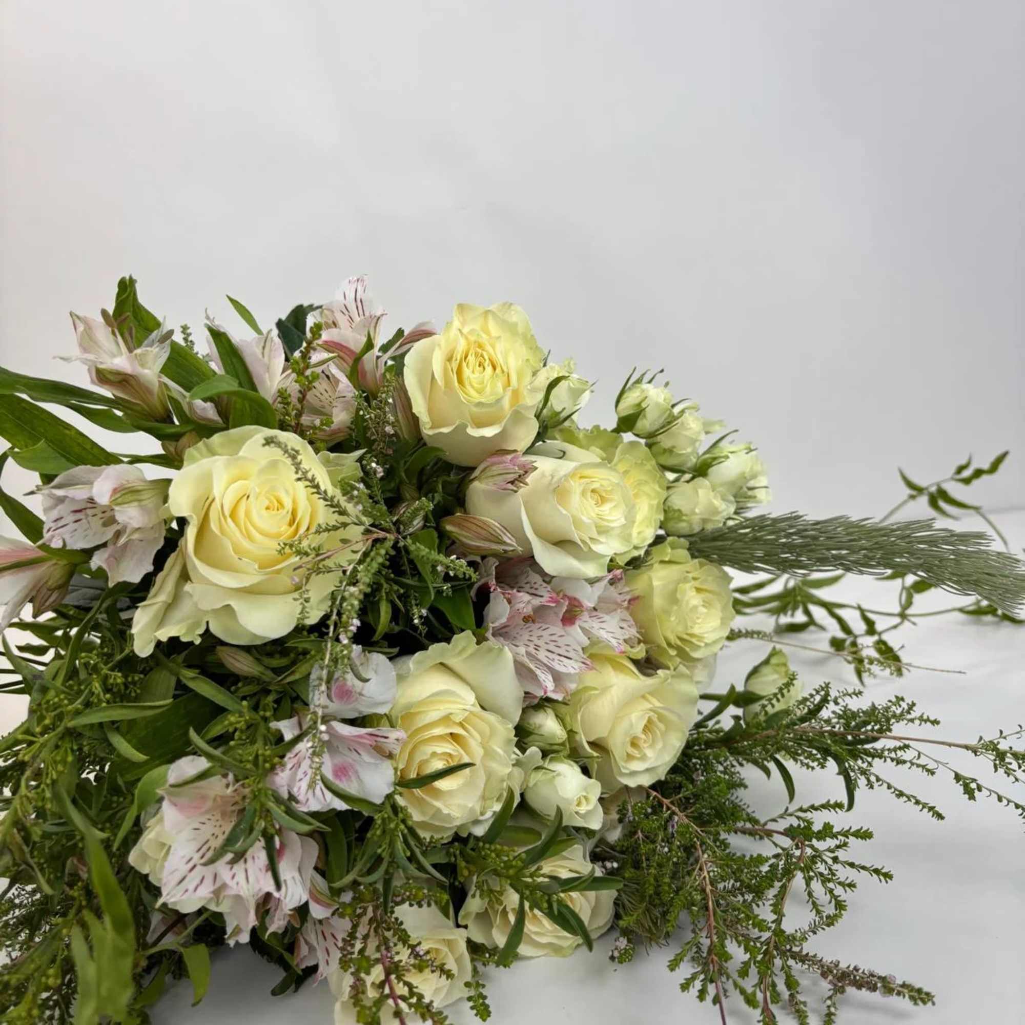 Bouquet of pale yellow roses and white alstroemeria with greenery