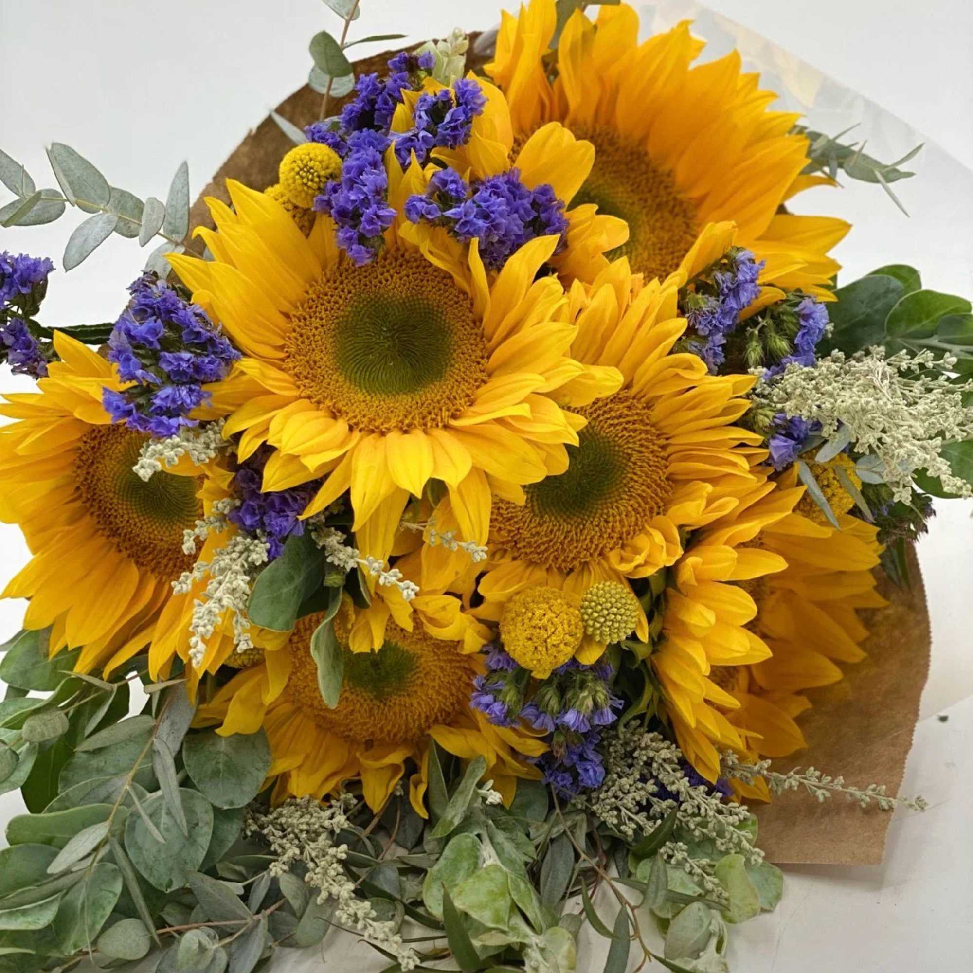 Bouquet of yellow sunflowers with purple accents and eucalyptus
