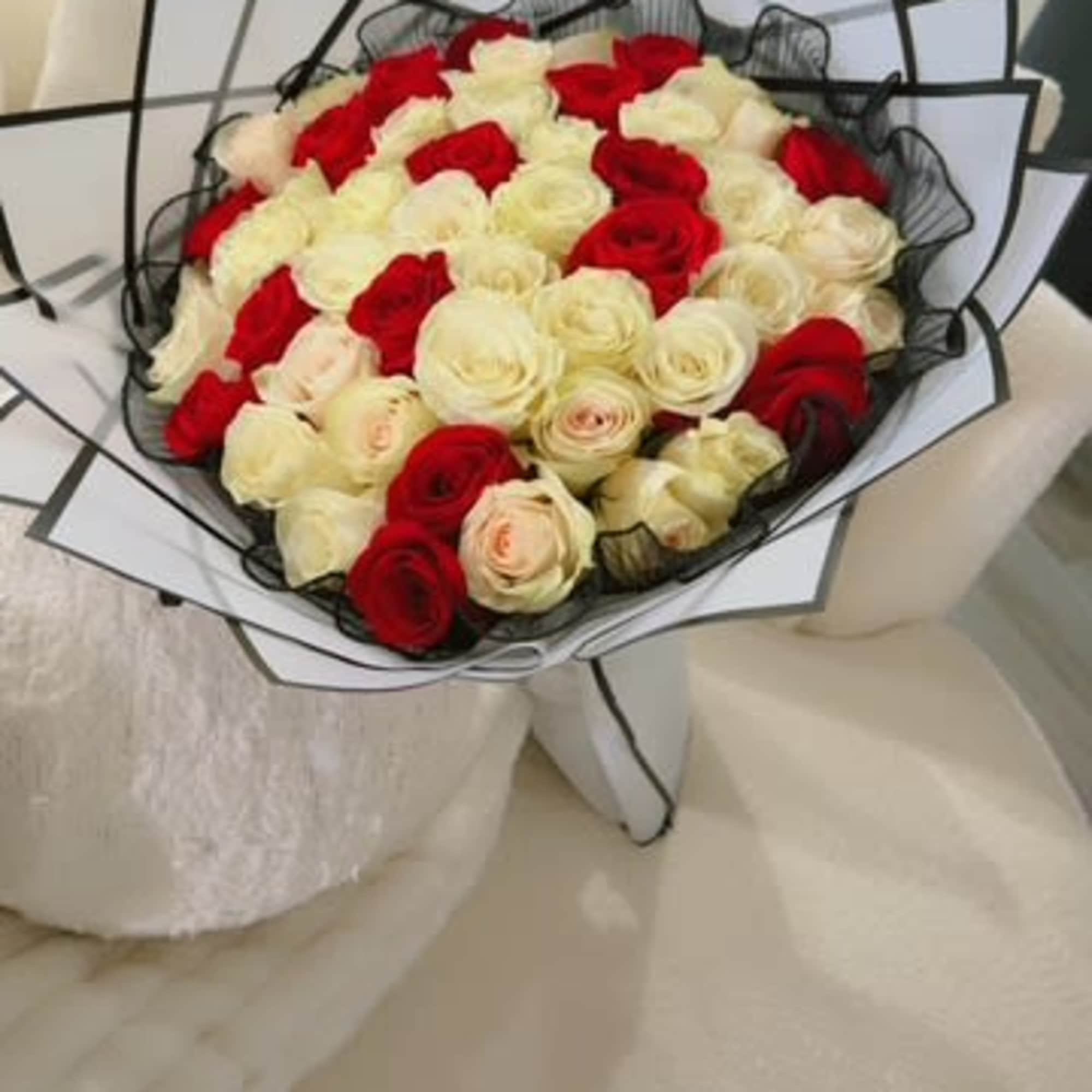 Bouquet of red and white roses wrapped in black and white paper