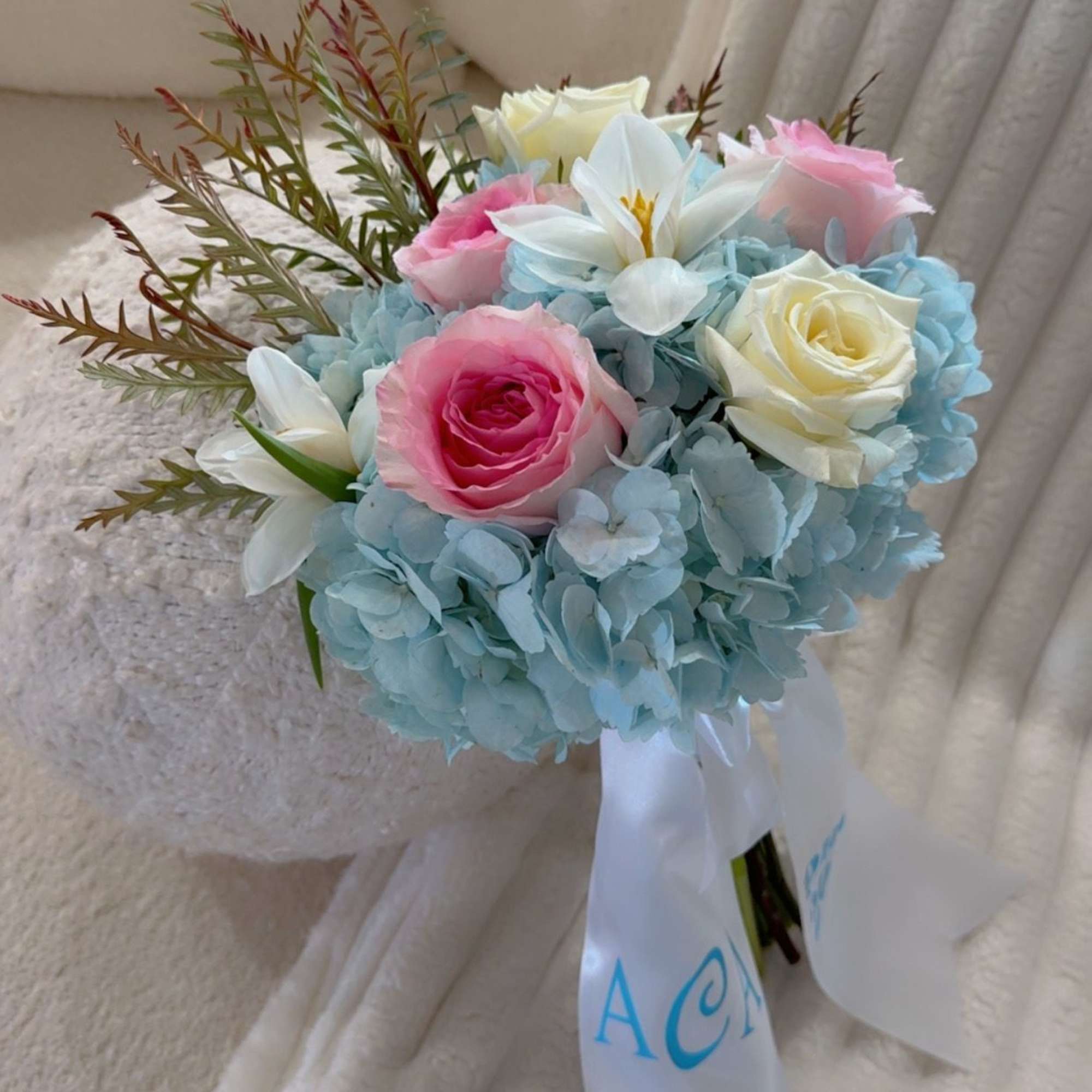A soft and romantic bouquet featuring sky-blue hydrangeas with blush and ivory