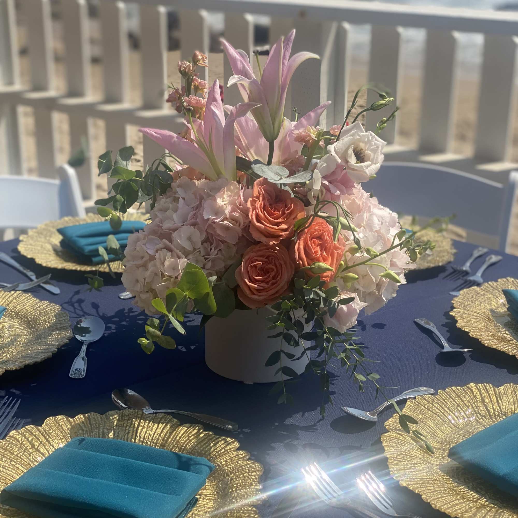 Pink and peach floral centerpiece in a white vase on a table